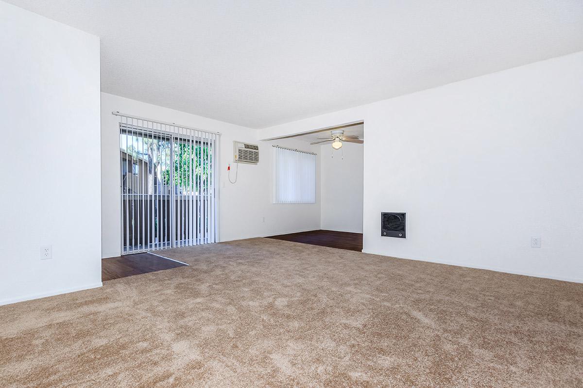 Unfurnished carpeted living room with sliding glass doors