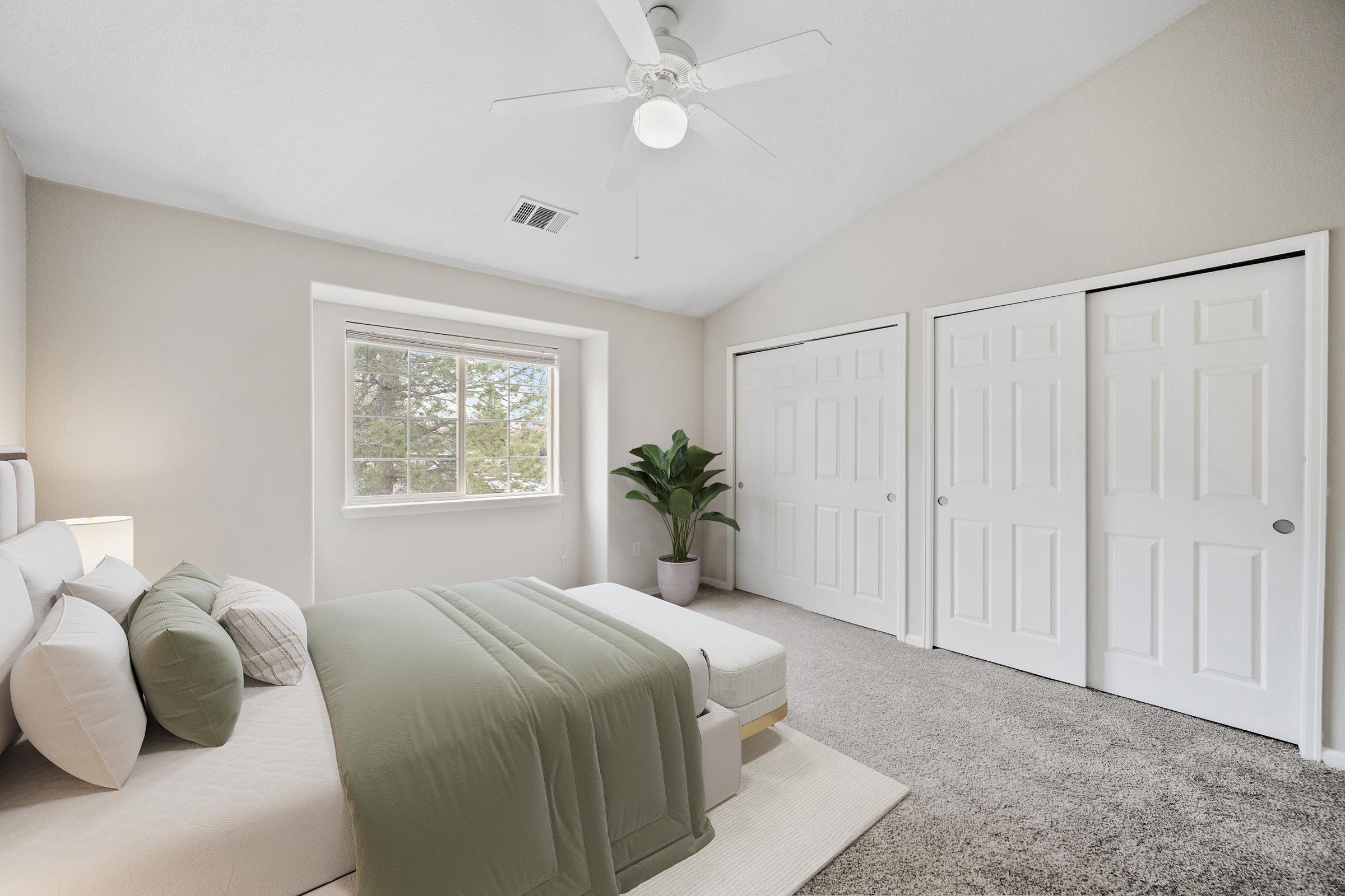 bedroom with window and closet doors.