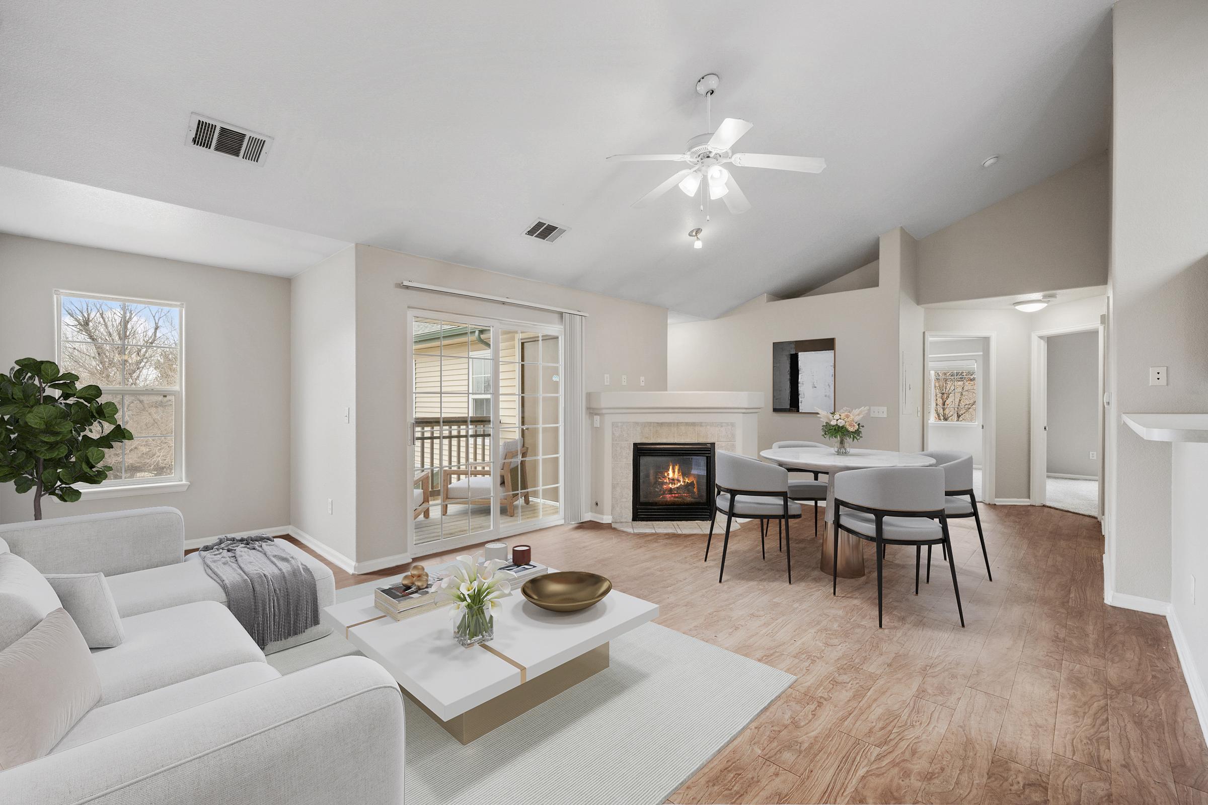 room with balcony door ceiling fan fireplace couch and dining table.