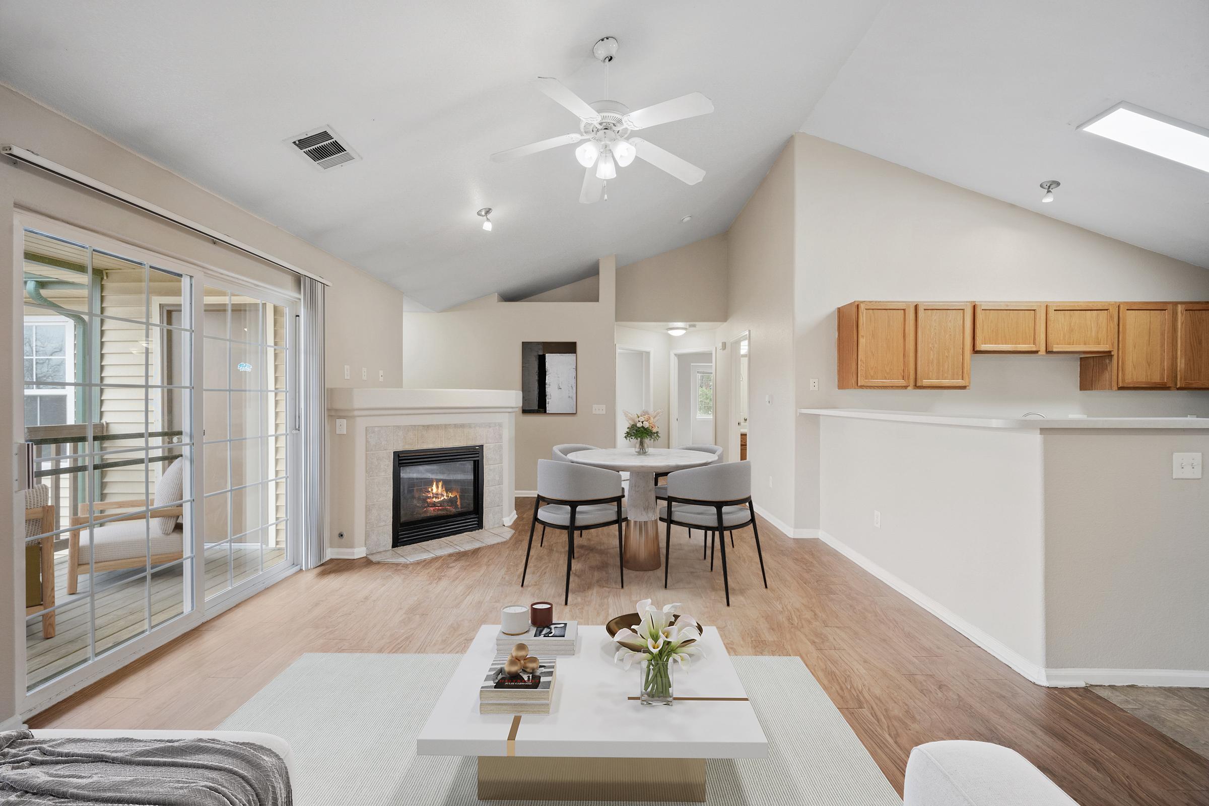 room with ceiling fan glass doors fireplace dining table and countertops.