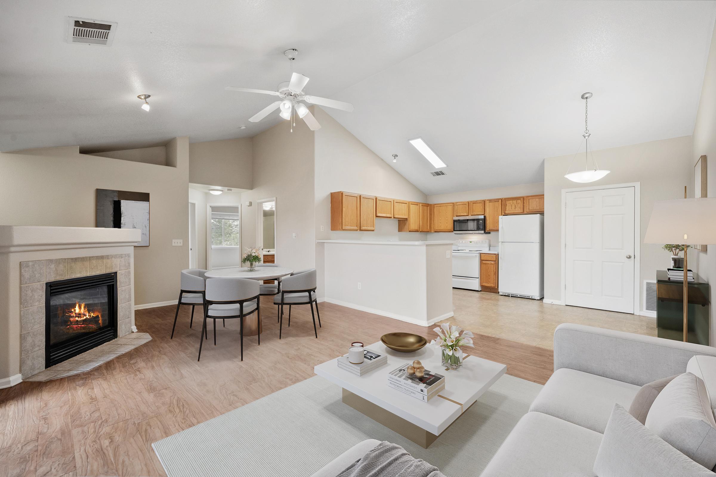 room with door refrigerator ceiling fan coffee table and fireplace.