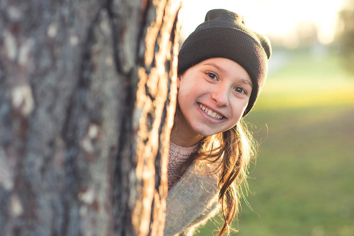 a close up of a girl wearing a hat and smiling at the camera