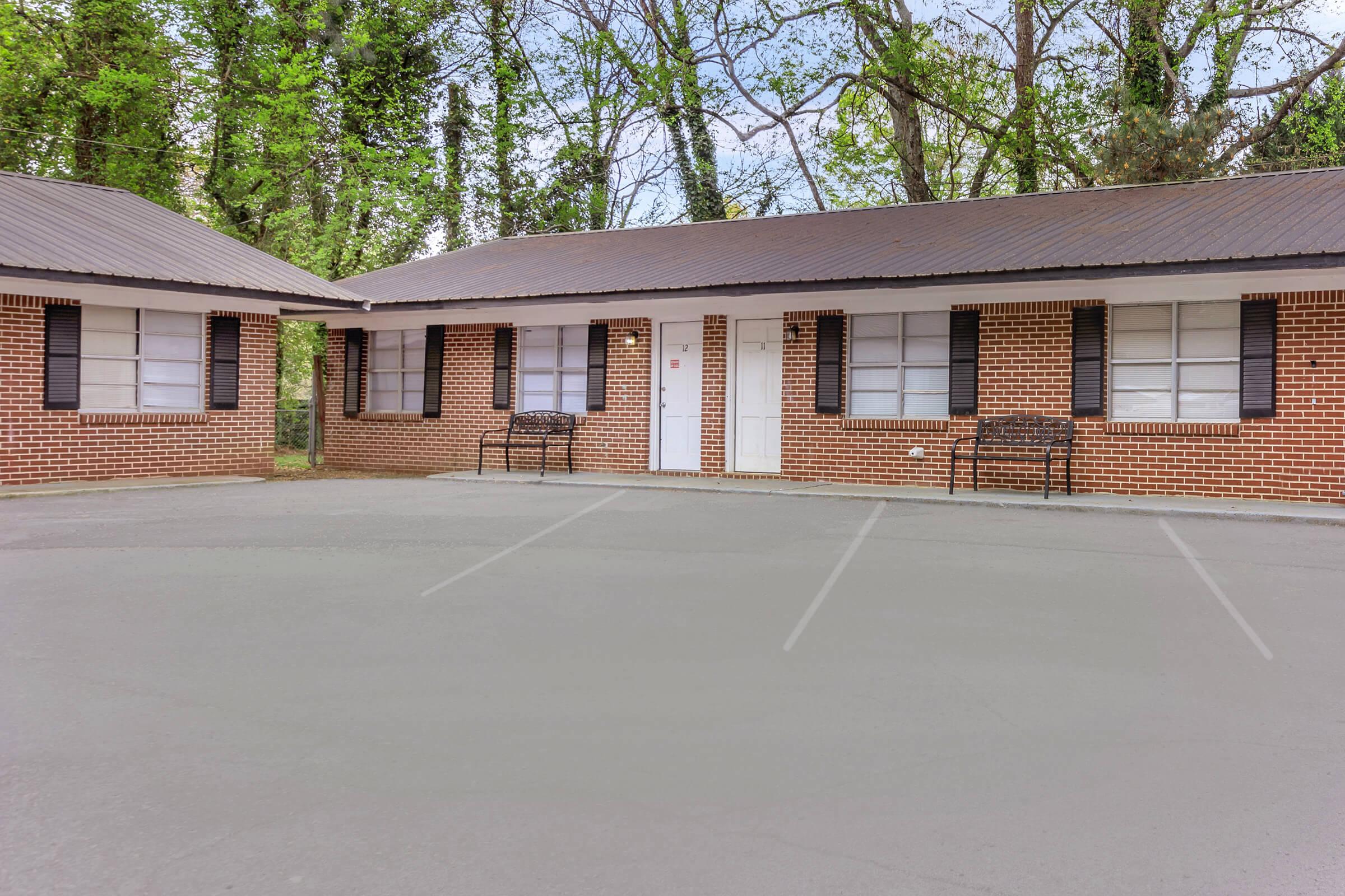 a house that has a racket in front of a brick building