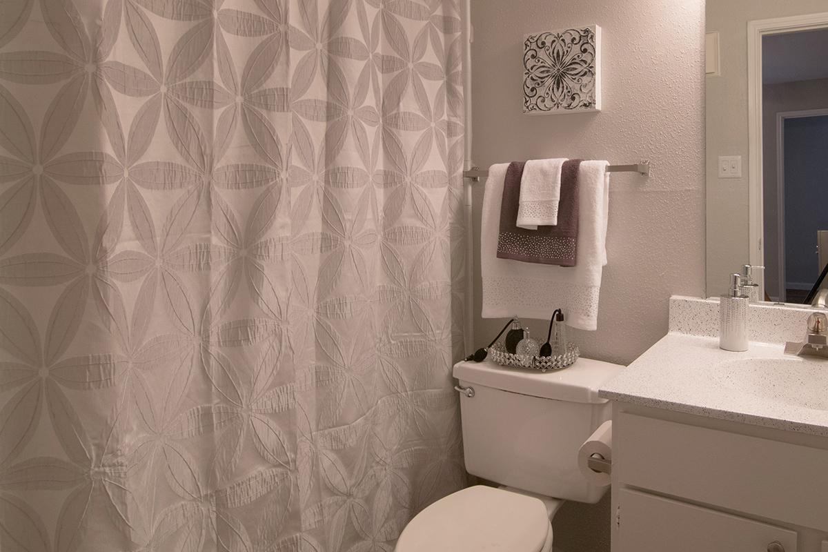 a white sink sitting next to a shower curtain