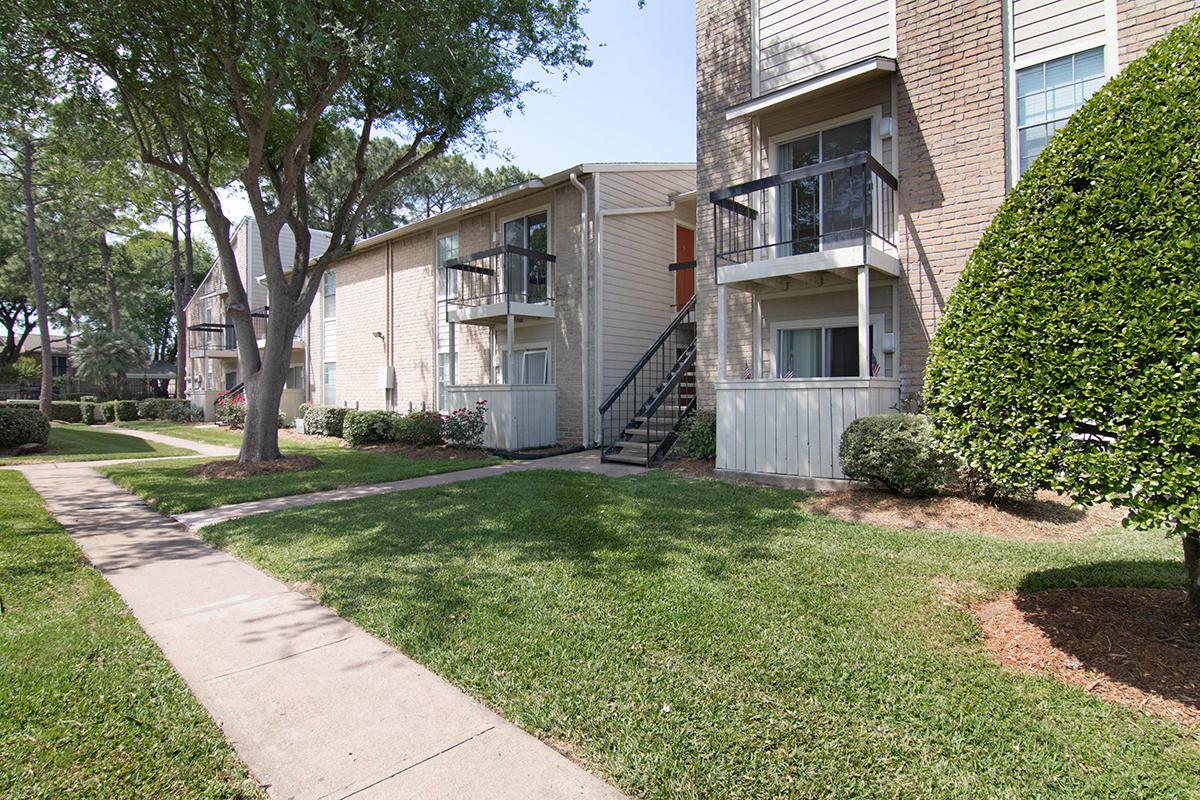 a house with a lawn in front of a brick building