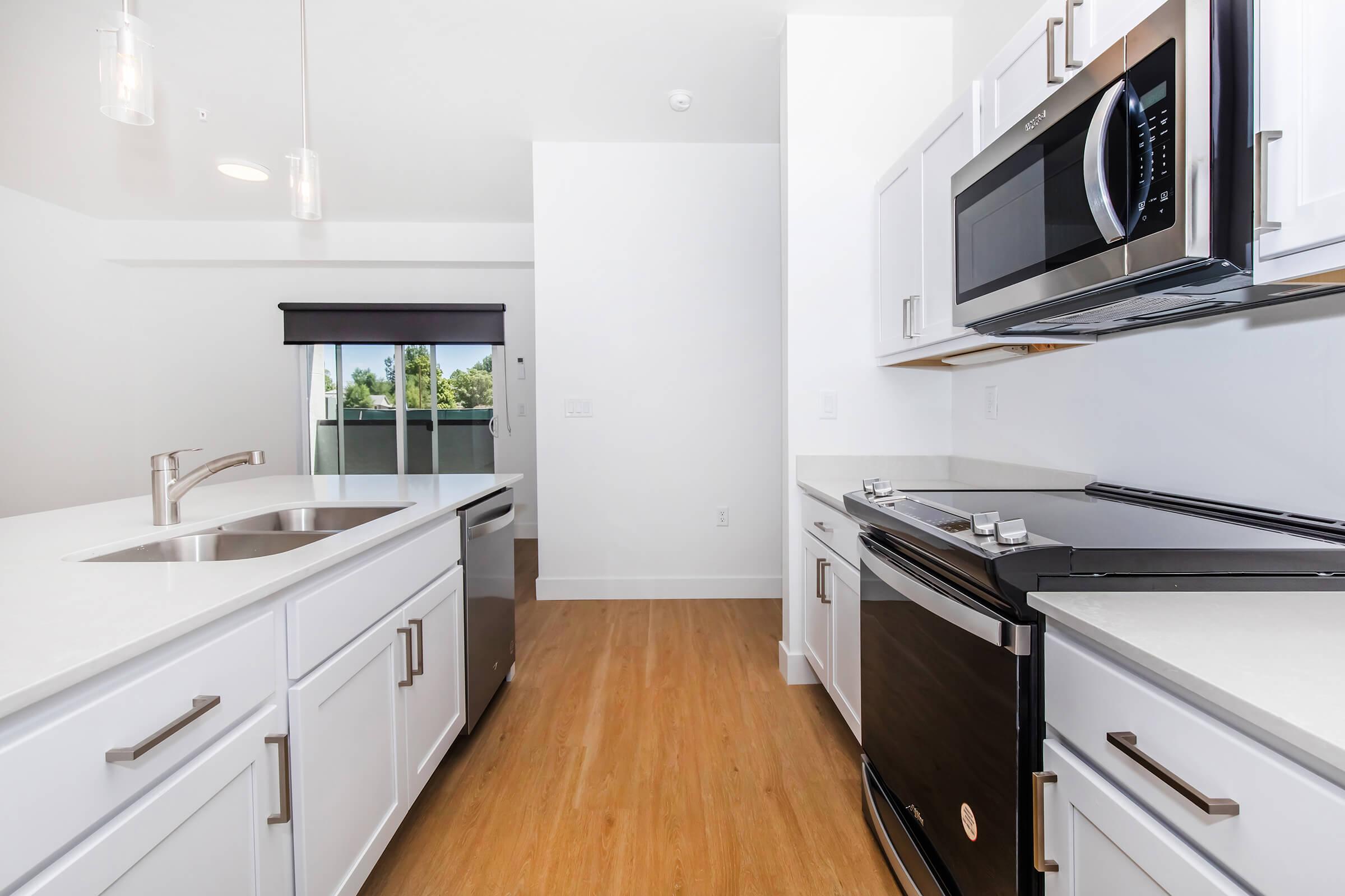 a kitchen with a stove a sink and a microwave