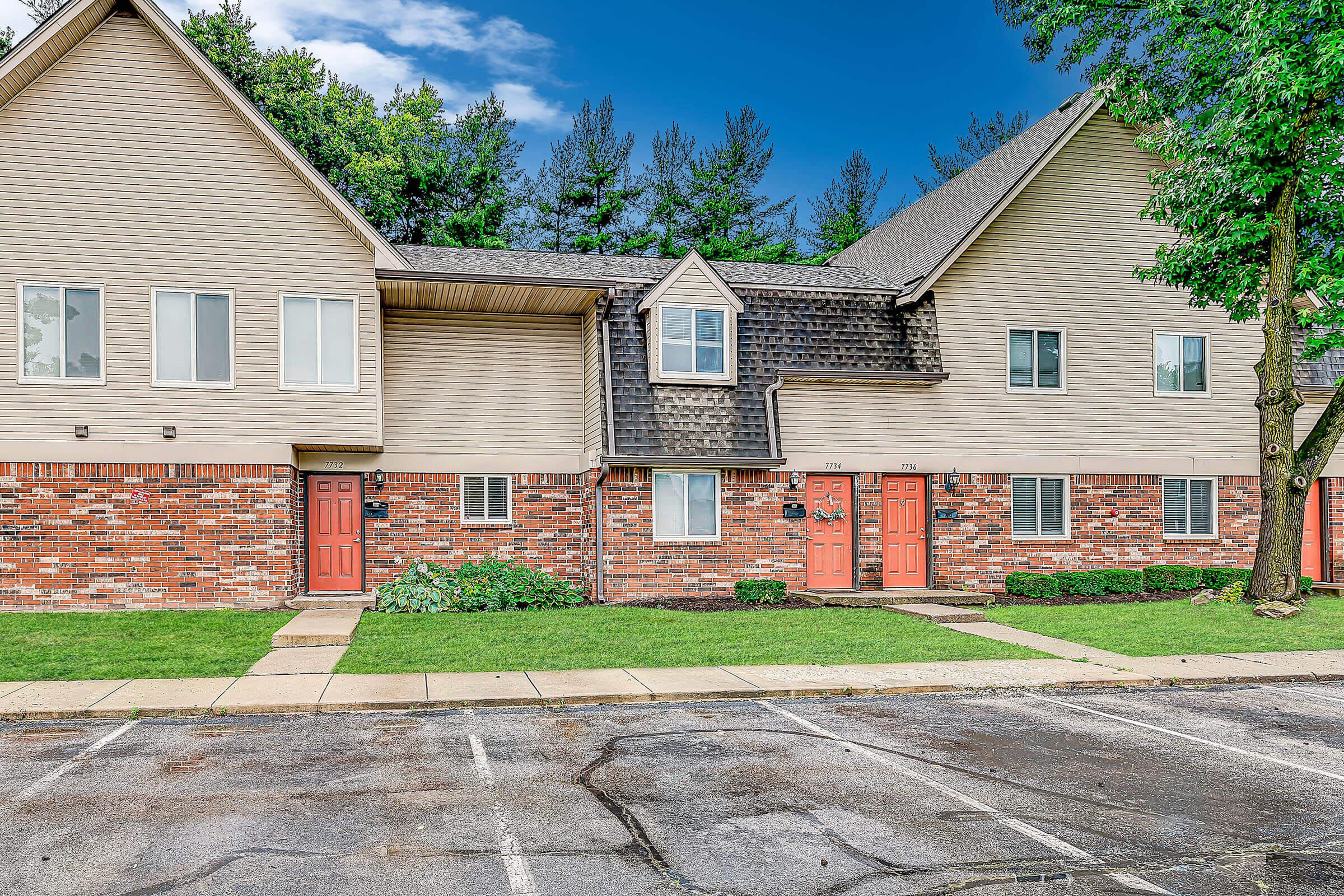 a large brick building with grass in front of a house