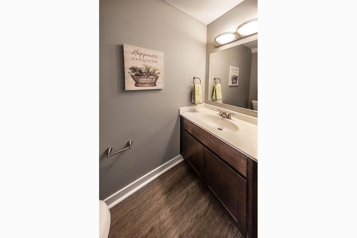 a white sink sitting under a mirror