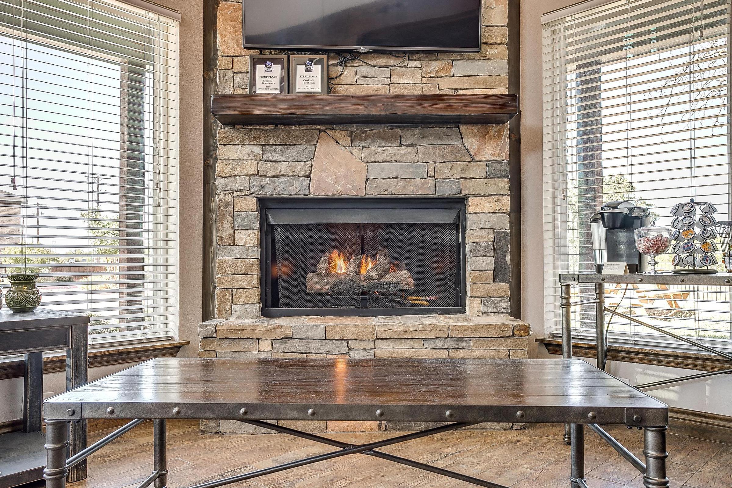 a fire place sitting in a chair next to a fireplace