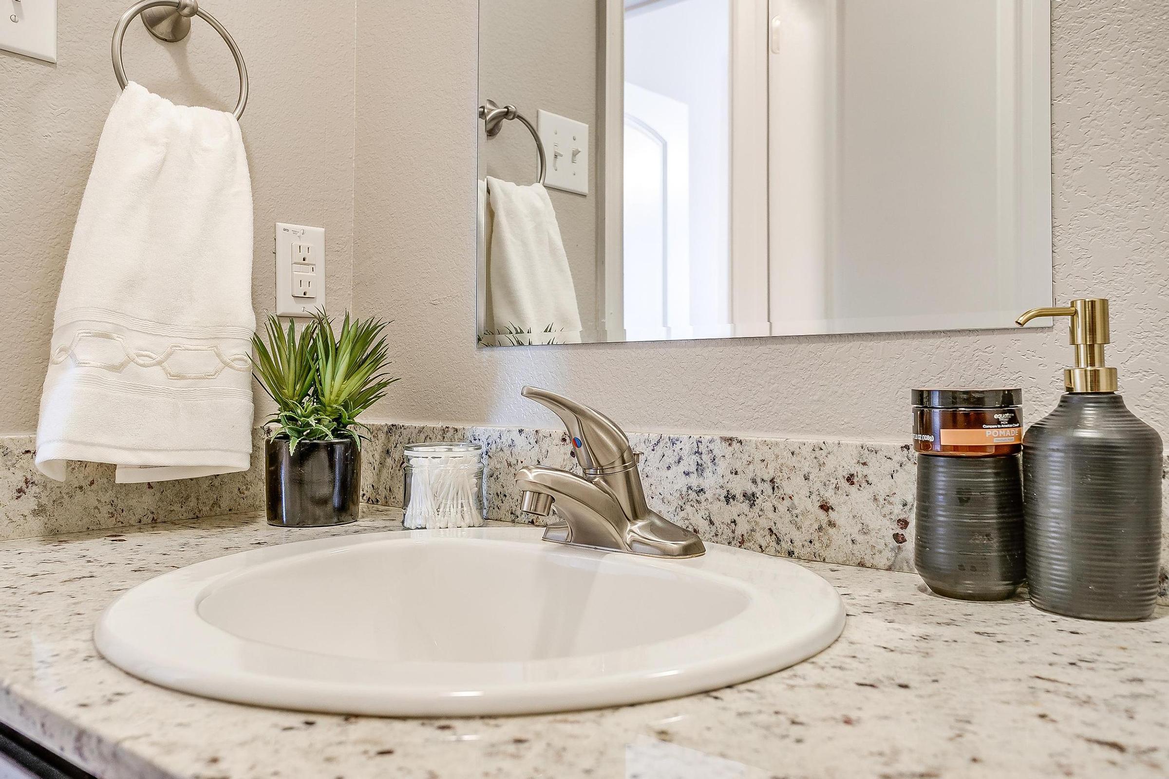 a counter with a sink and a mirror