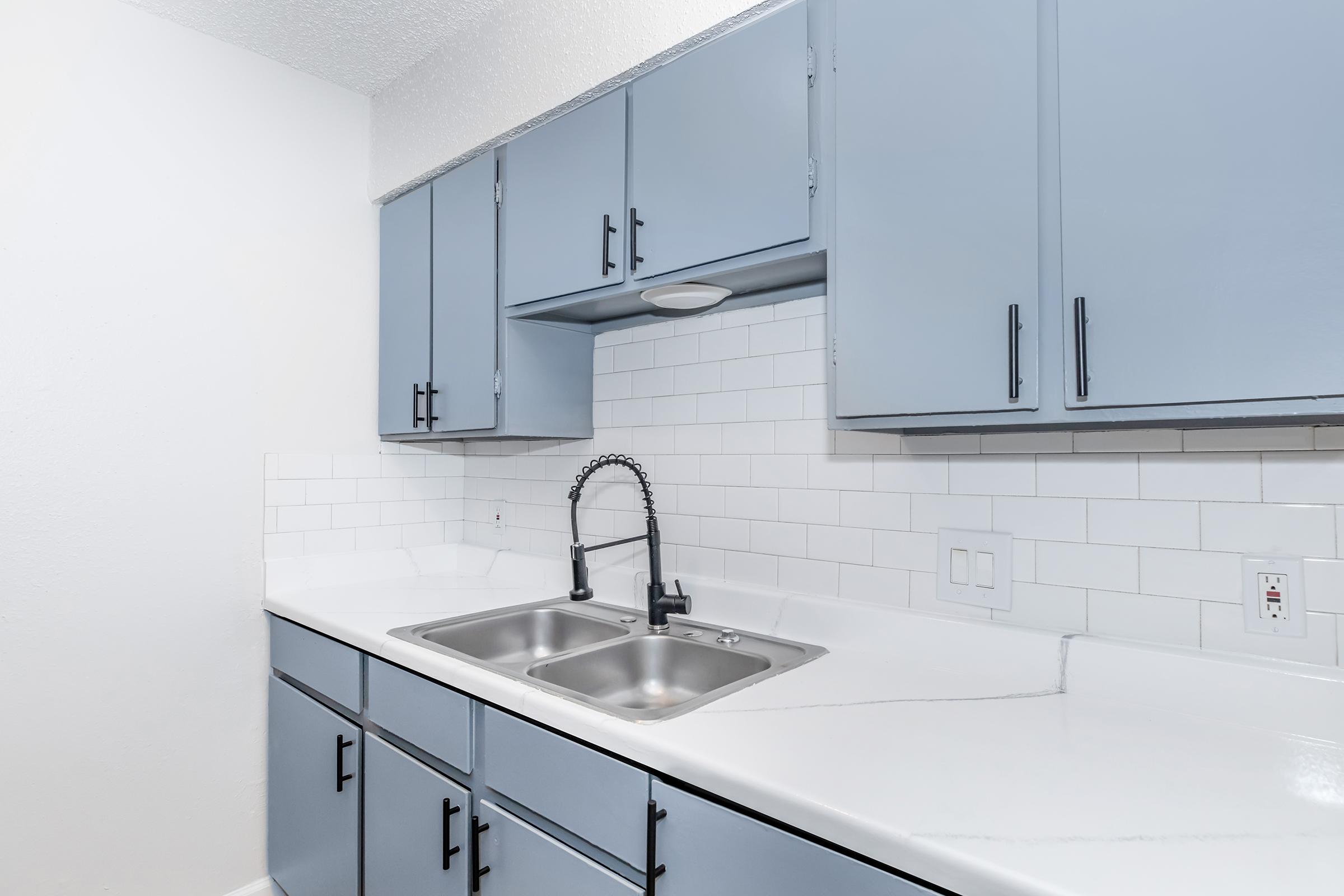 a kitchen with a sink and a mirror