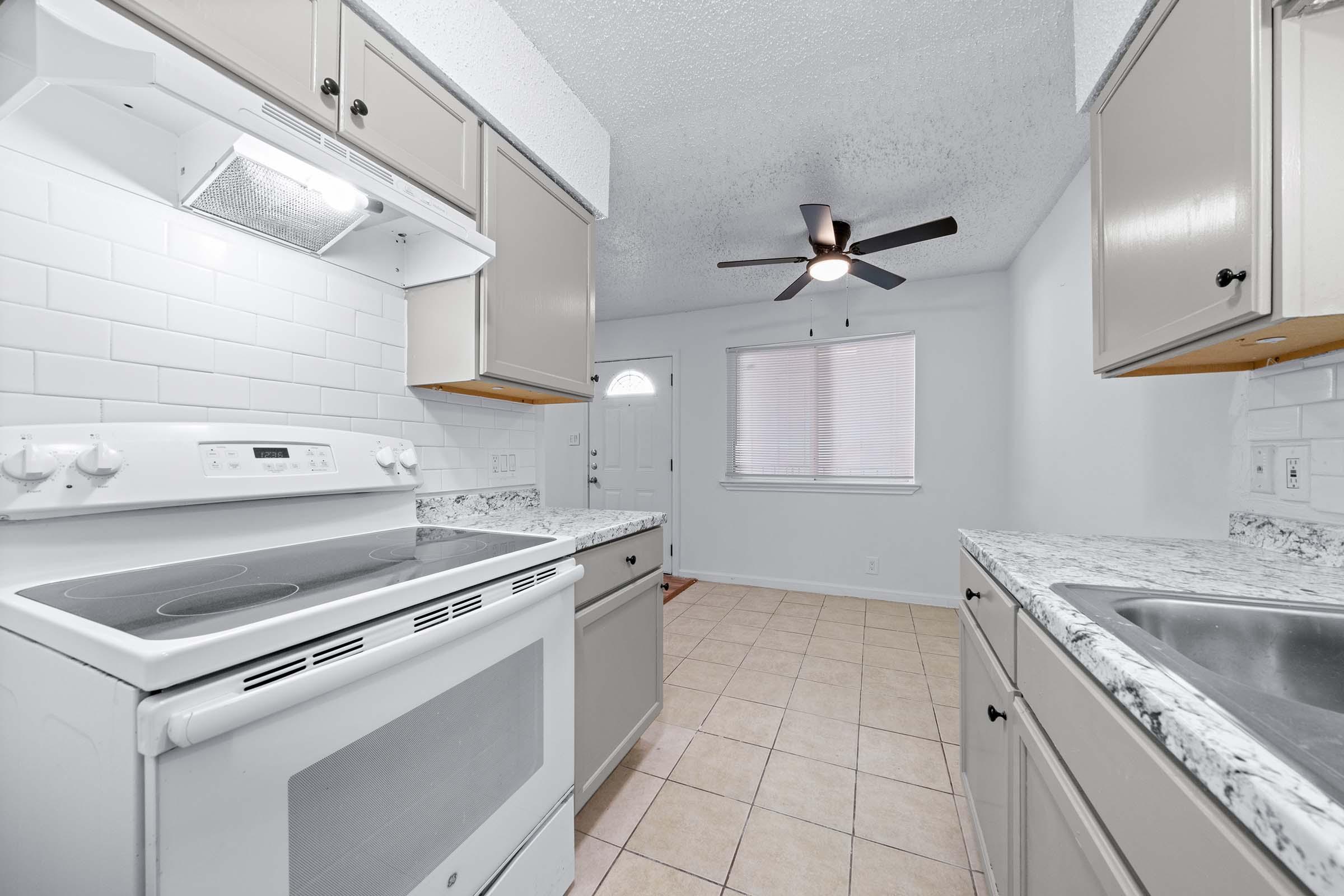 a stove top oven sitting inside of a kitchen