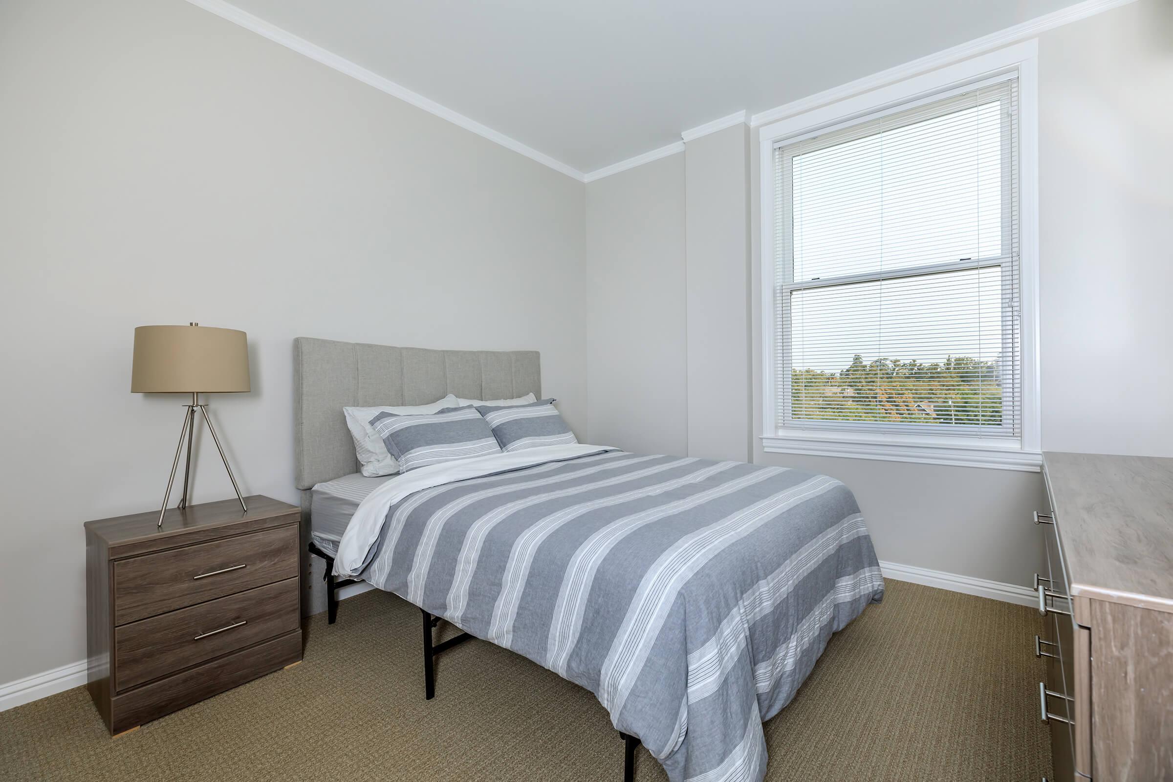 a bedroom with a bed and desk in a room