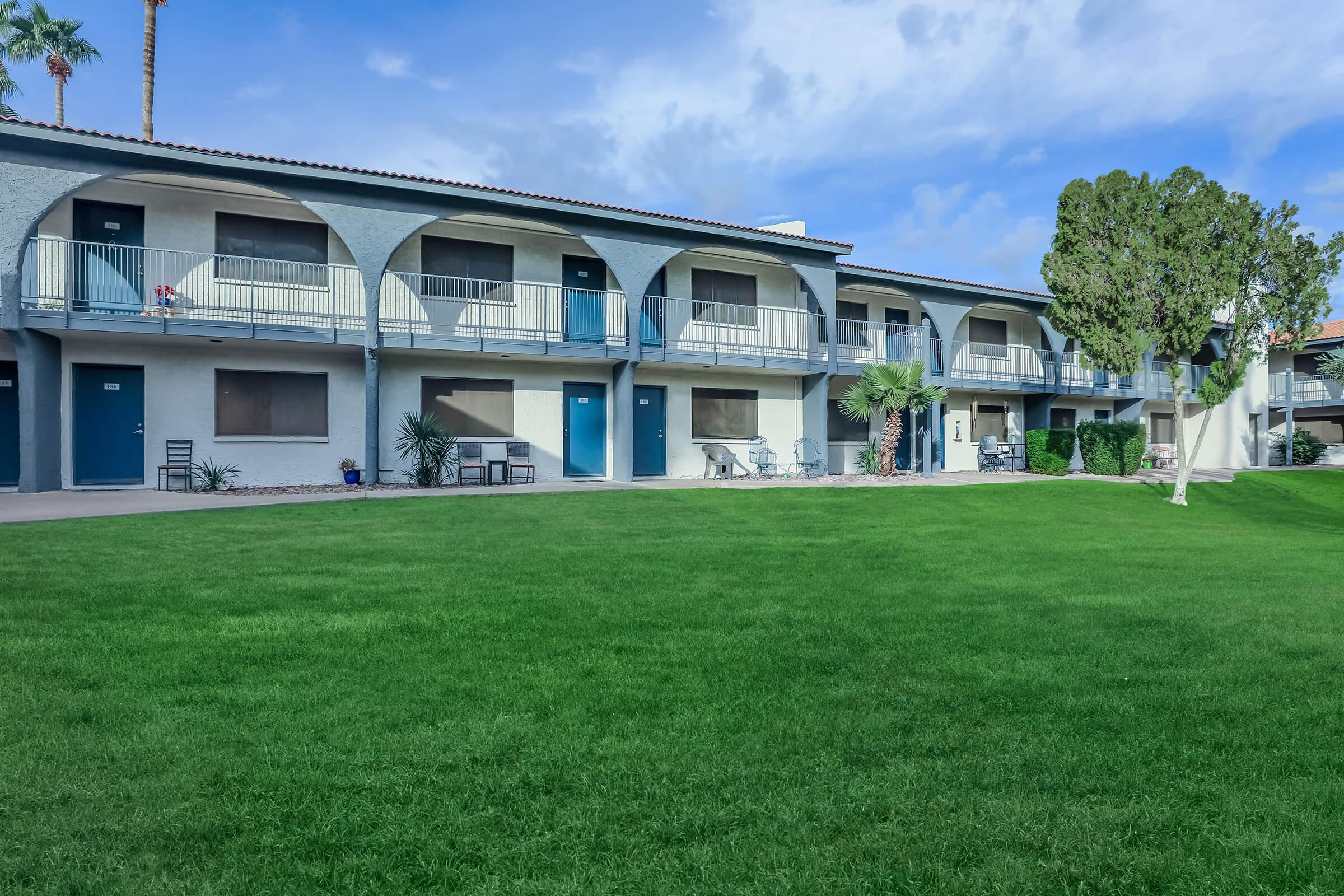 Large exterior apartment building with. large lot of grass in the front