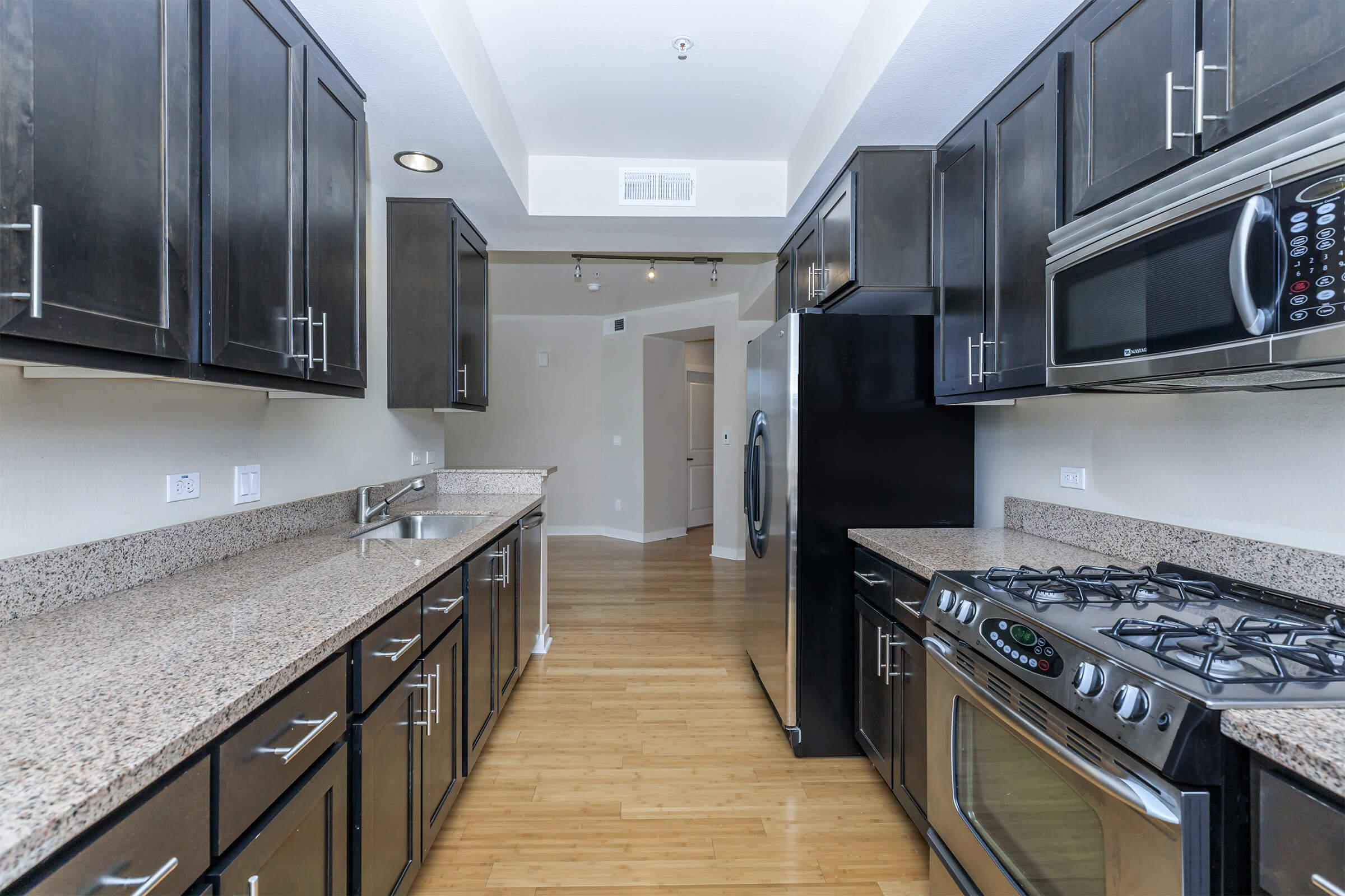 a modern kitchen with stainless steel appliances and wooden cabinets