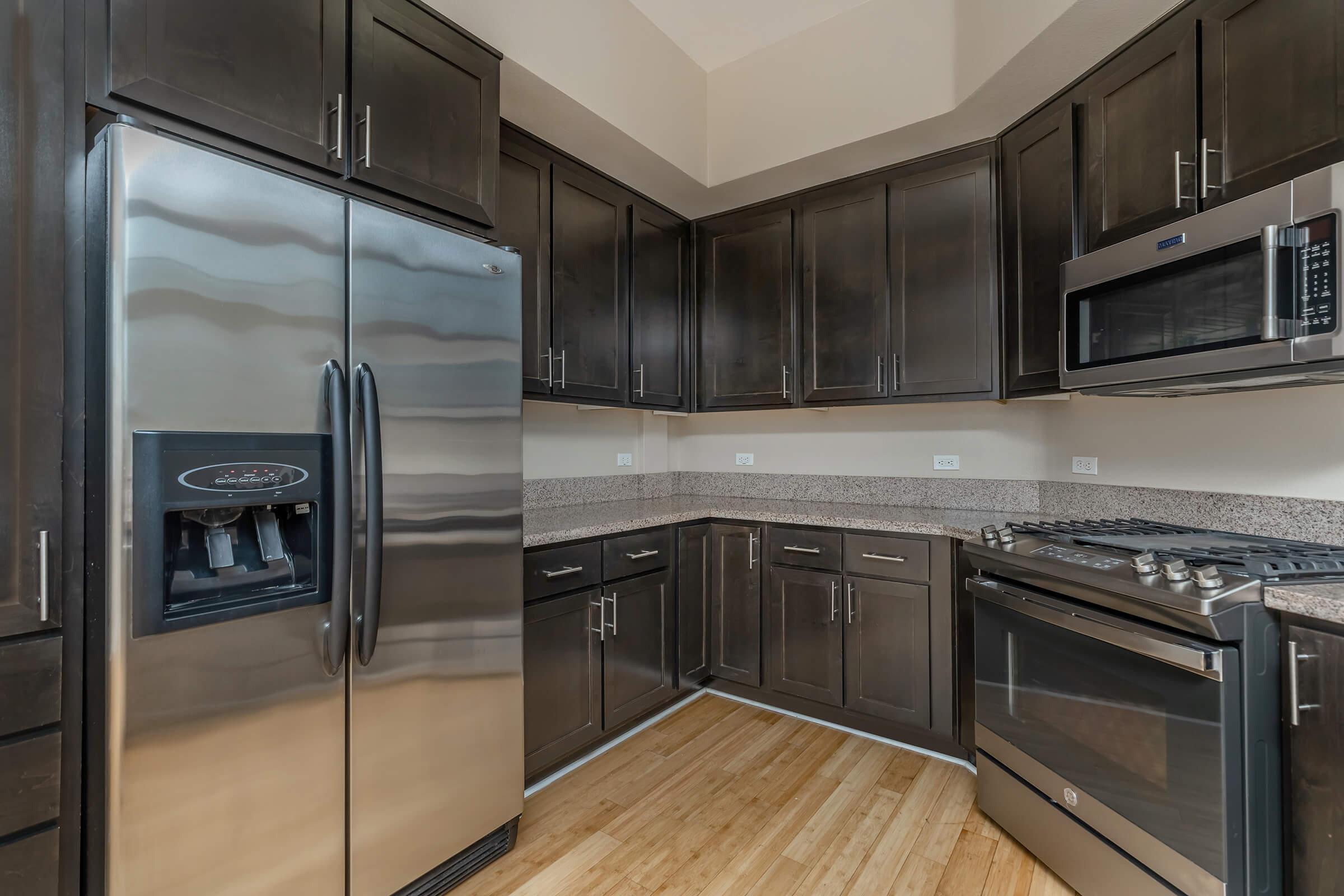 a large kitchen with stainless steel appliances and wooden cabinets