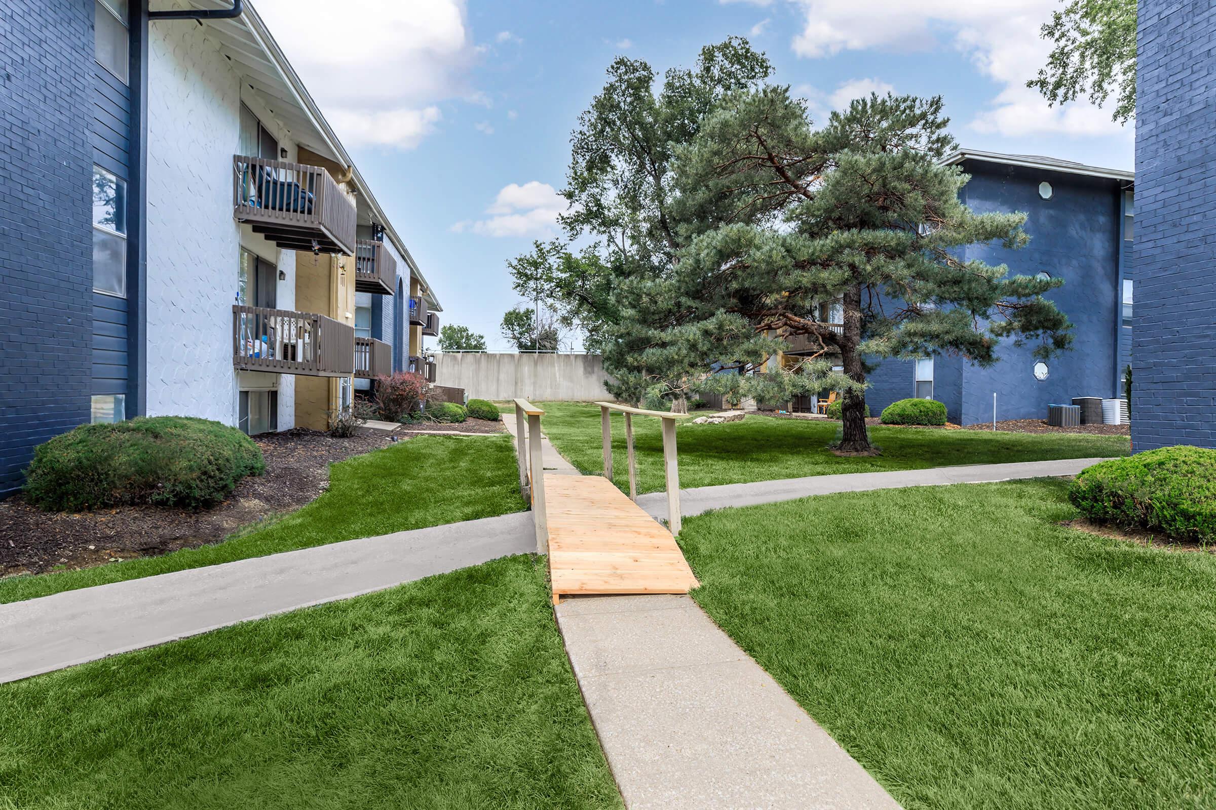 a house with a lawn in front of a brick building