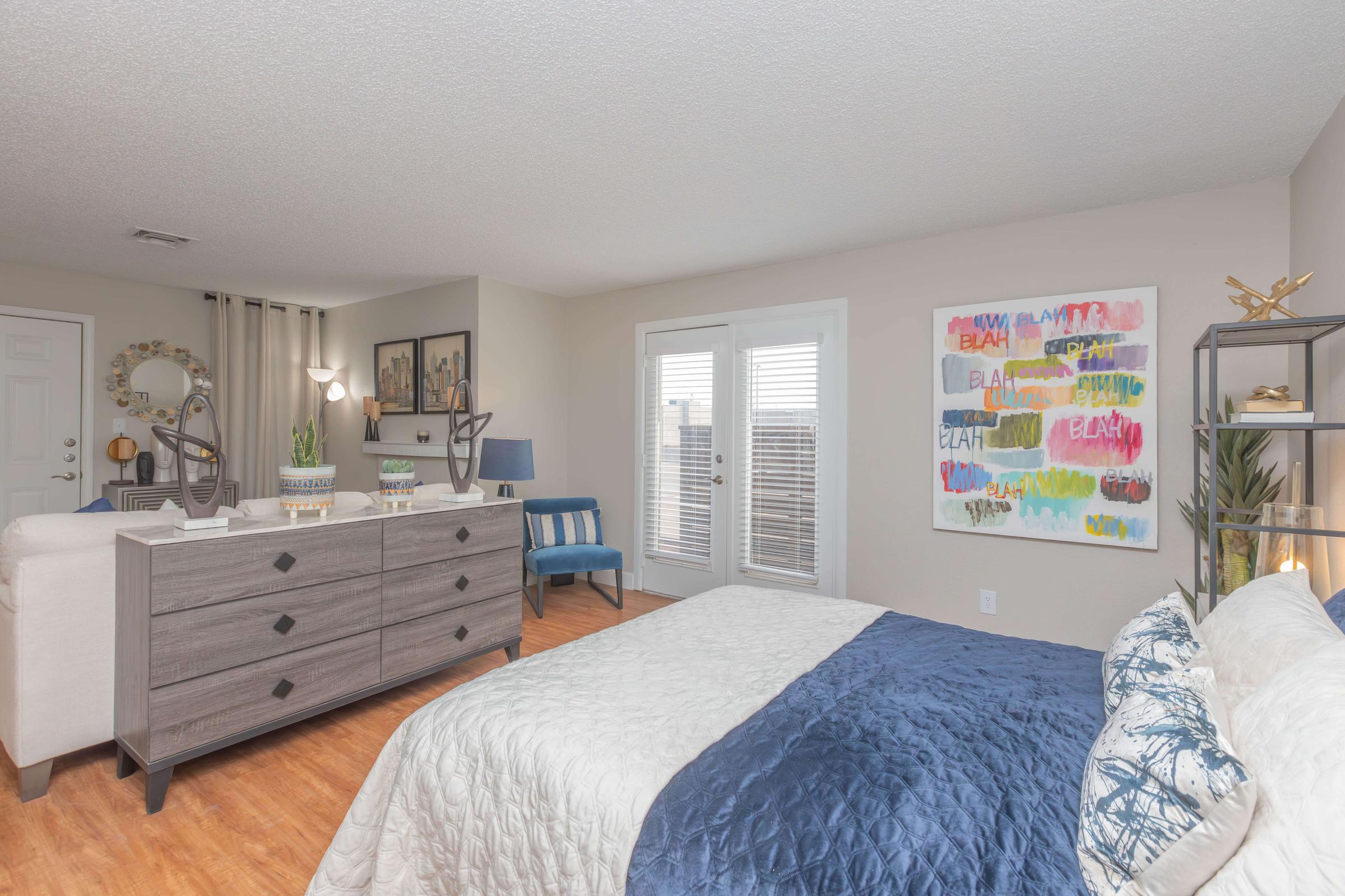 a bedroom with a bed and desk in a room