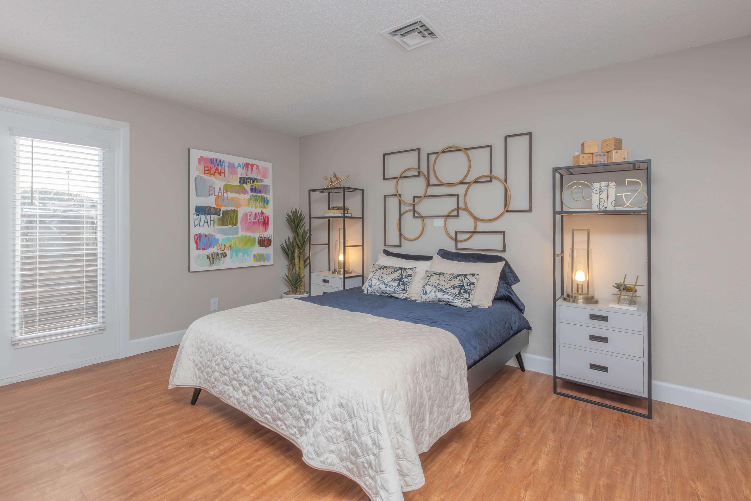 a bedroom with a bed and desk in a room