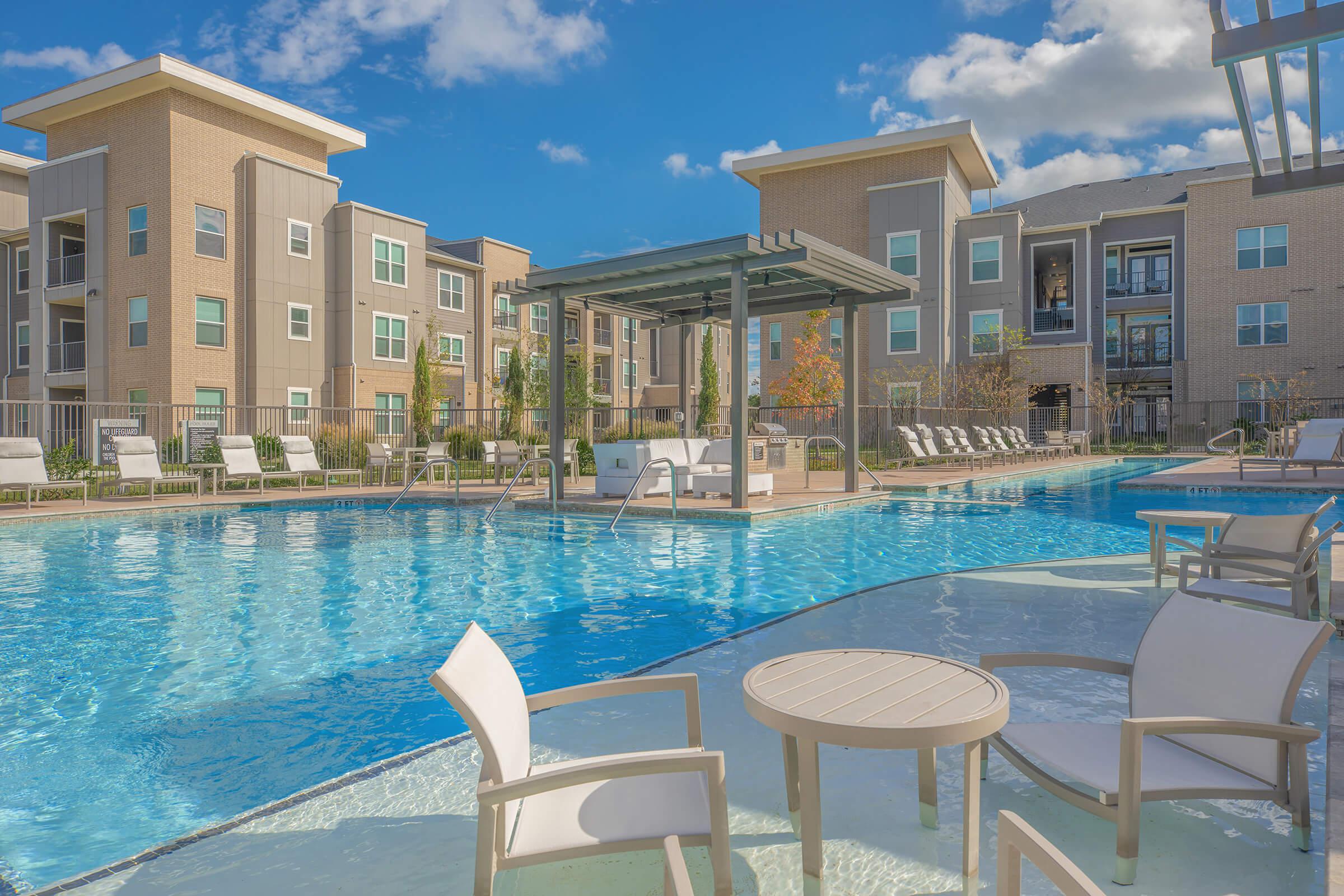 a group of lawn chairs sitting next to a pool of water