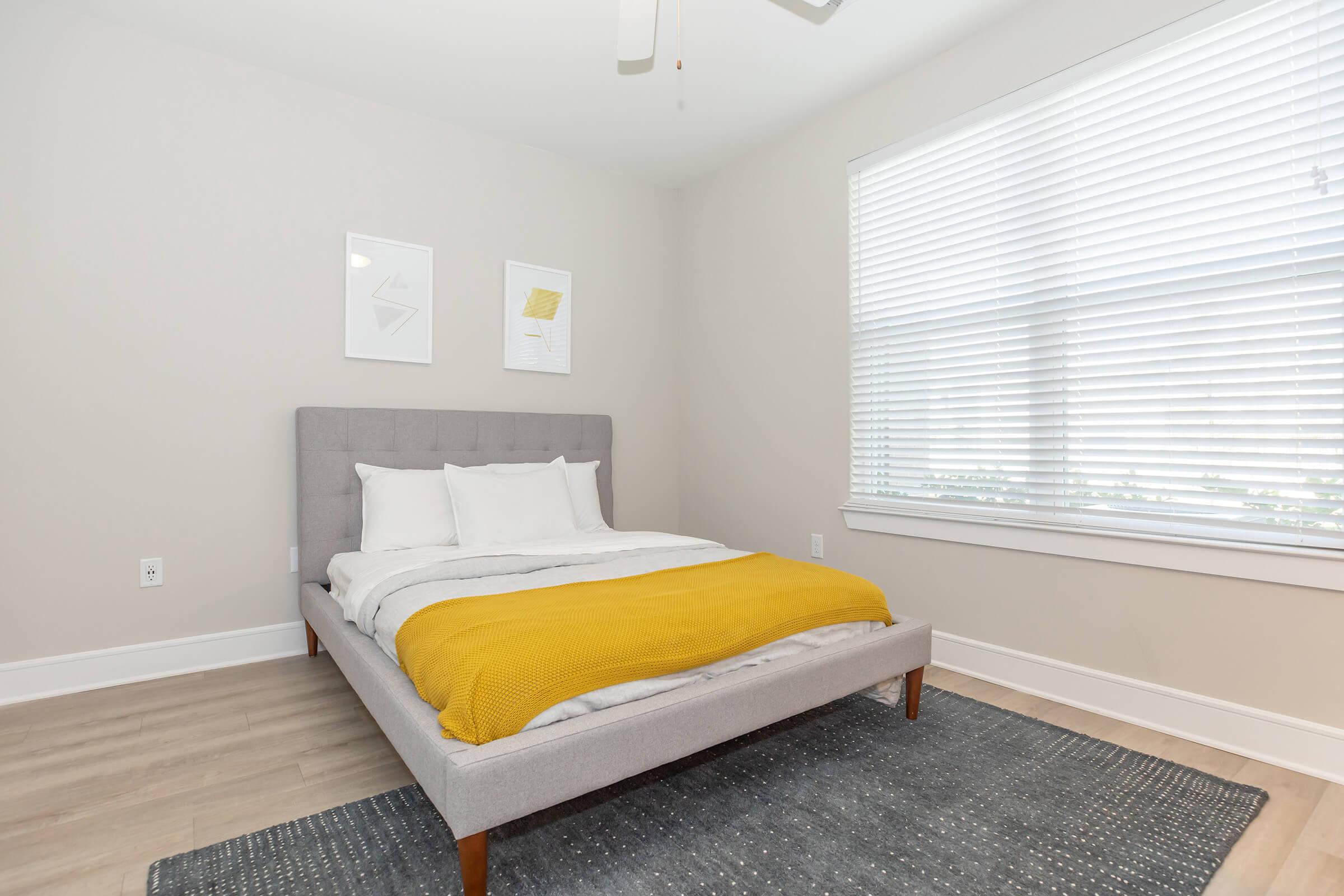 a bedroom with a bed and a chair in a room