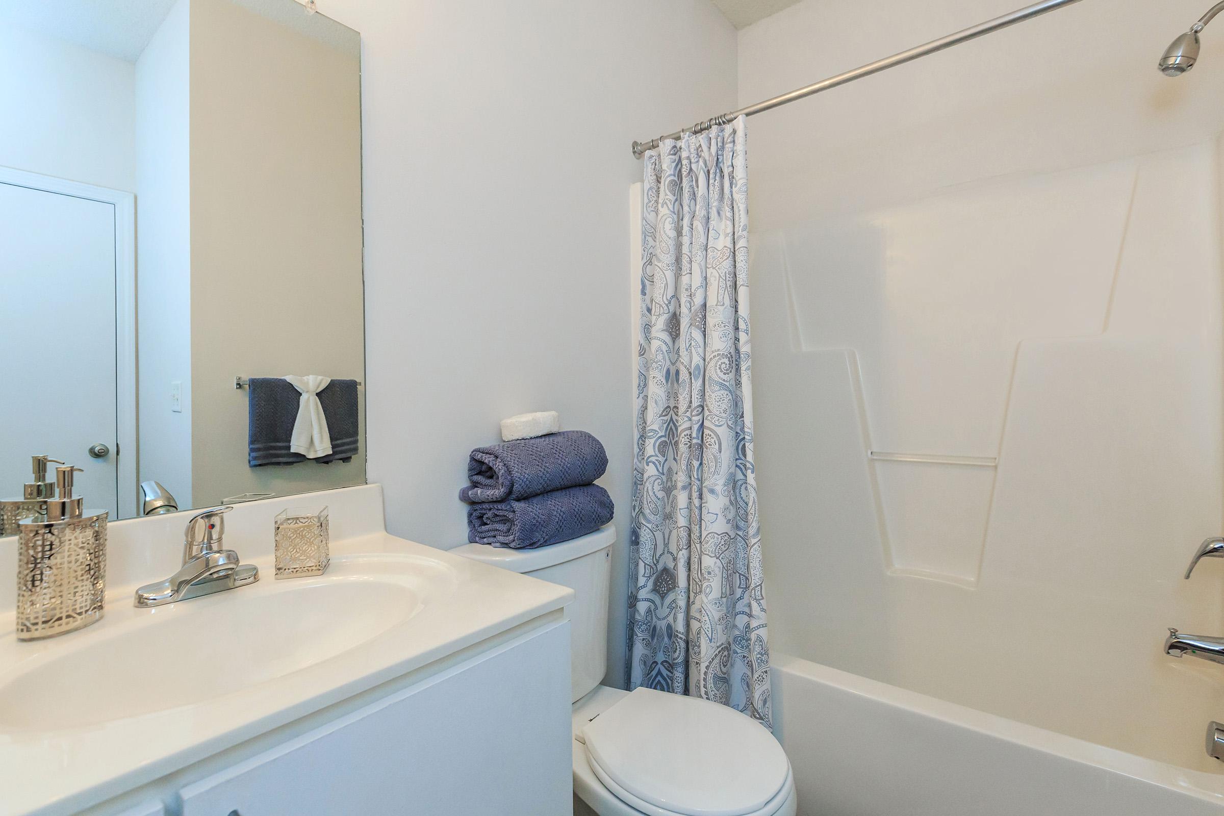 a white sink sitting under a mirror