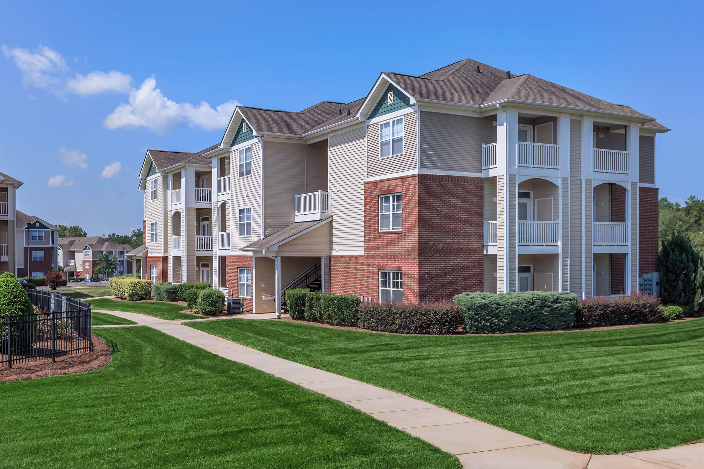 a large lawn in front of a brick building