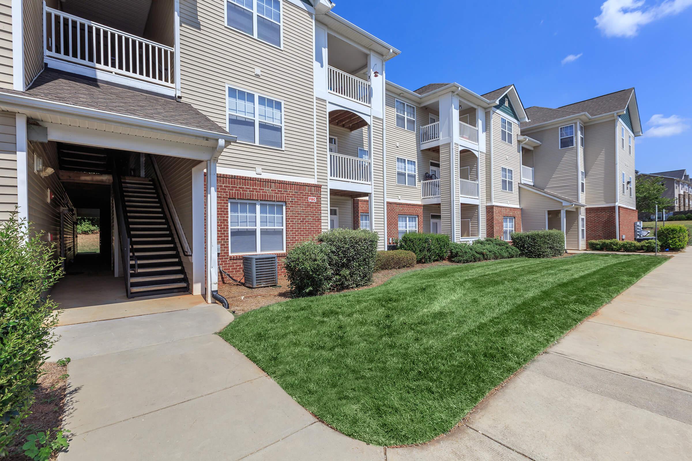 a large brick building with grass in front of a house