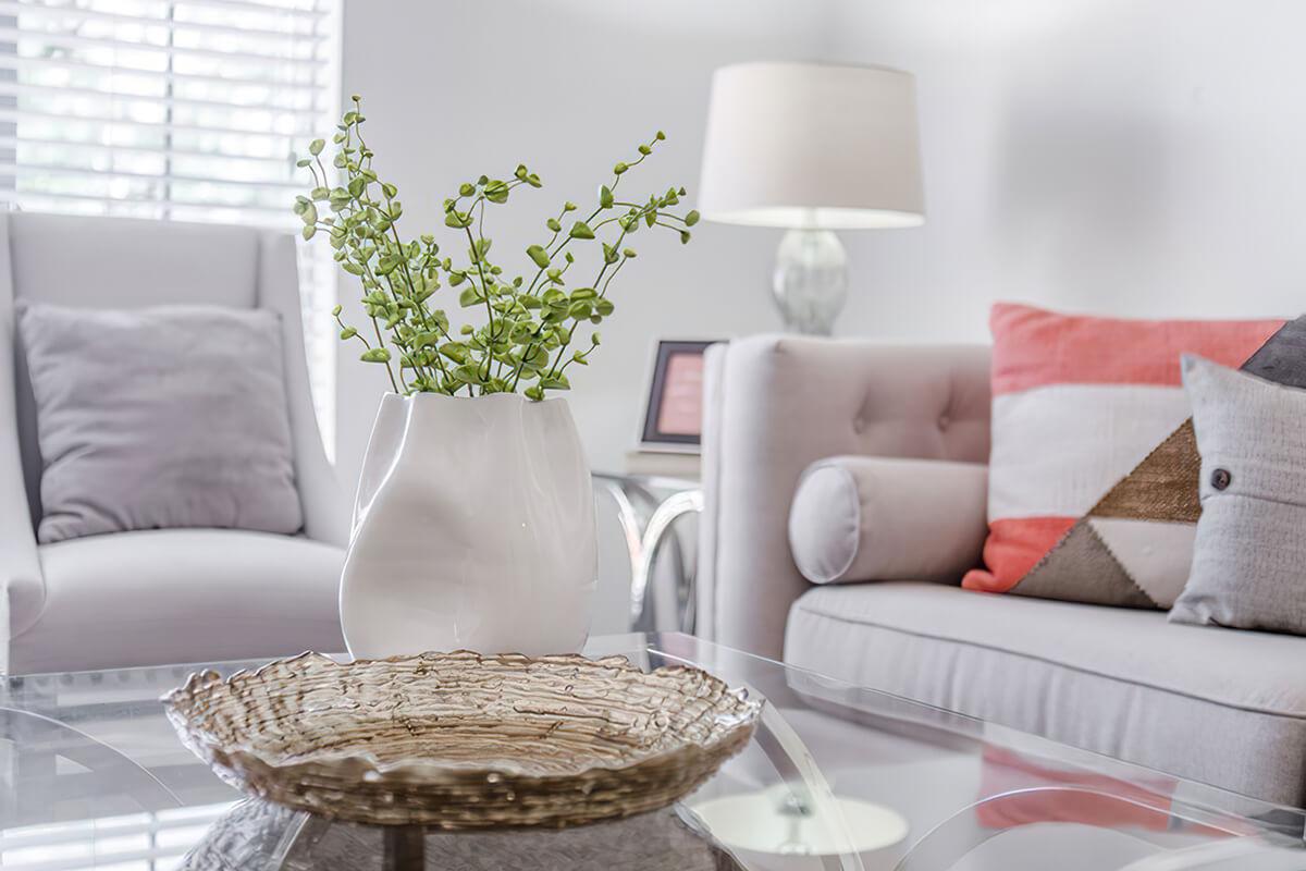 a living room filled with furniture and vase of flowers on a table