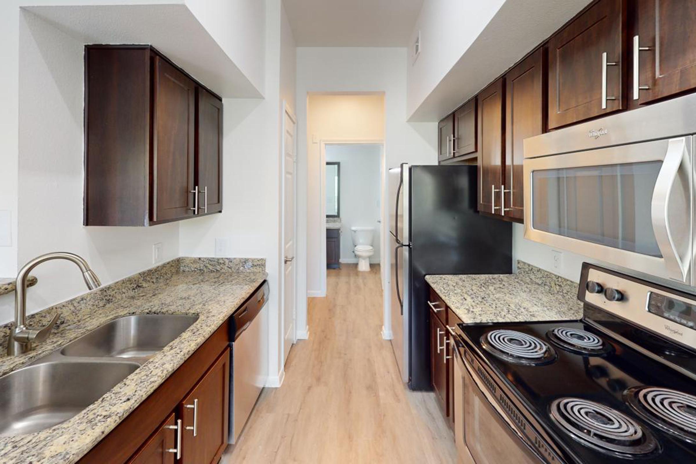 a modern kitchen with stainless steel appliances and wooden cabinets