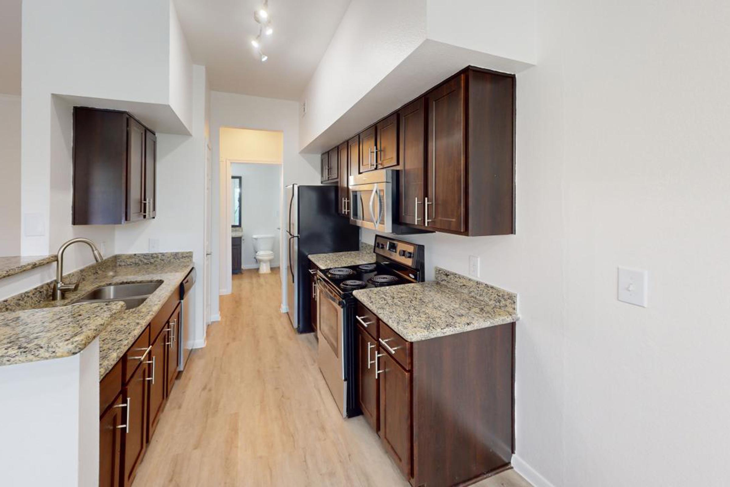 a large kitchen with stainless steel appliances and wooden cabinets