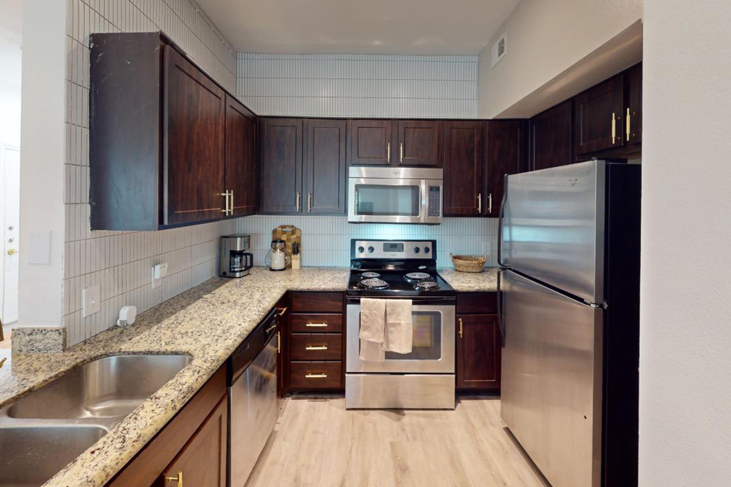 a modern kitchen with stainless steel appliances and wooden cabinets