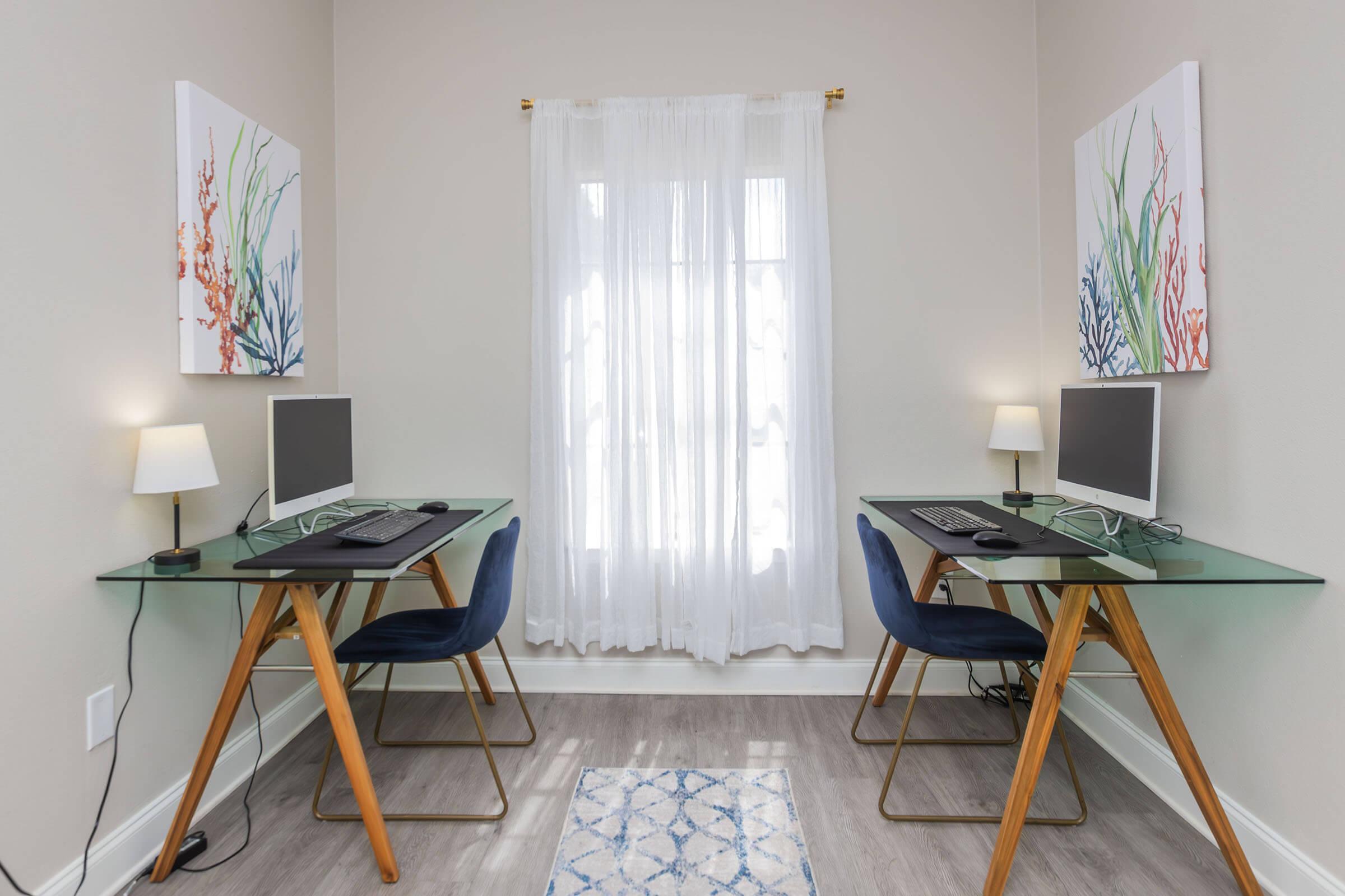 a desk with a computer and a chair in a room