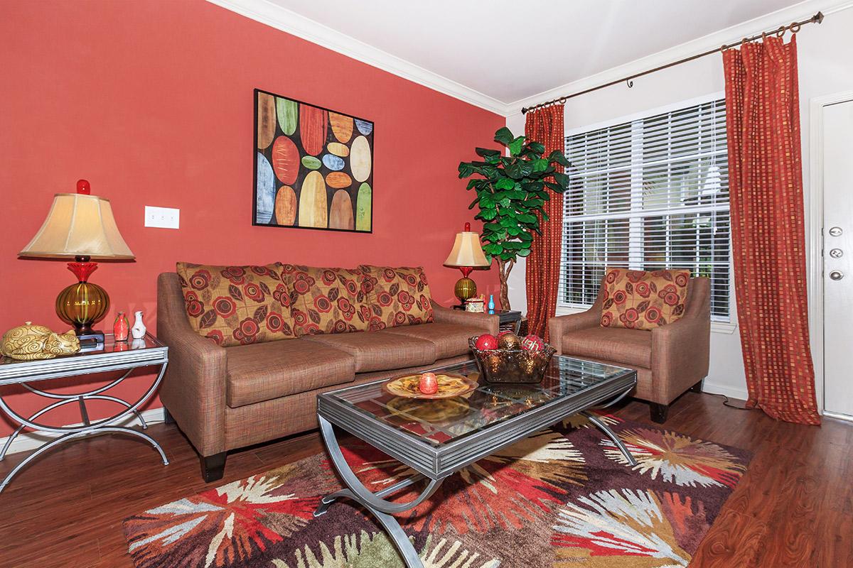 a living room filled with furniture and a red rug
