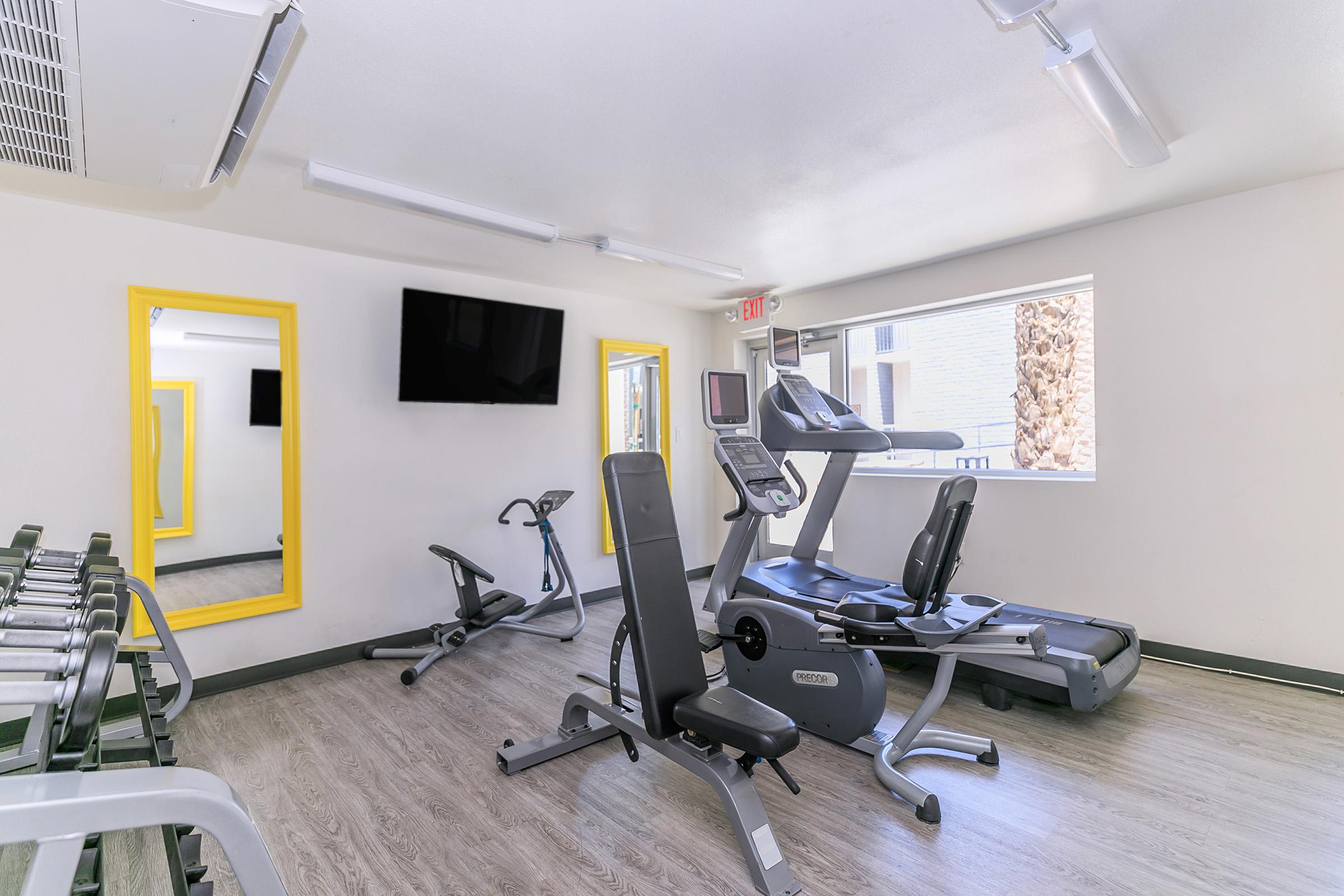 Rise Canyon West's modern indoor fitness center with gym equipment, flat-screen TV and a window