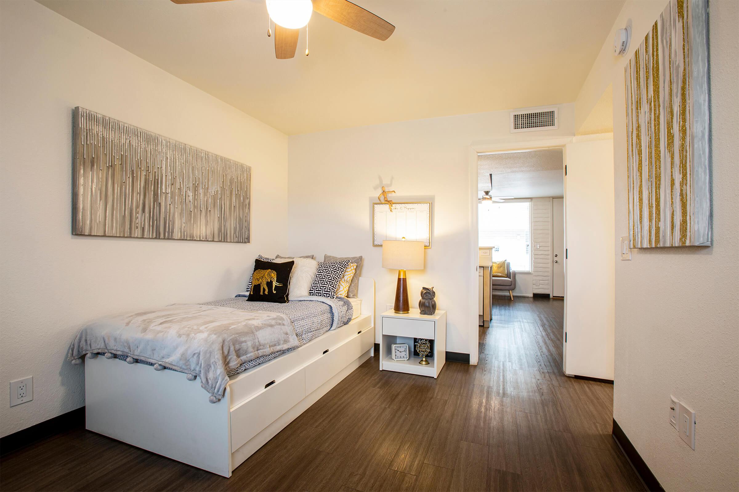 Spacious Rise Canyon West bedroom with twin bed, dark wood flooring and ceiling fan