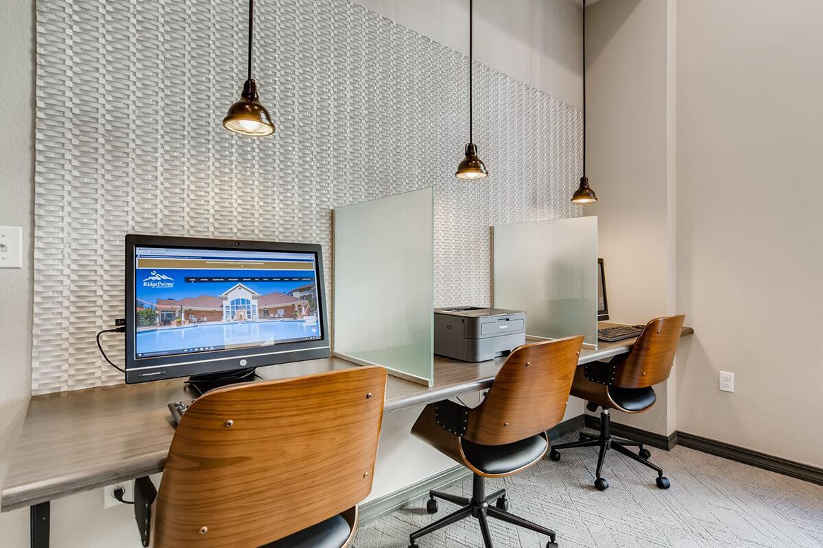 a desk with a computer and a chair in a room