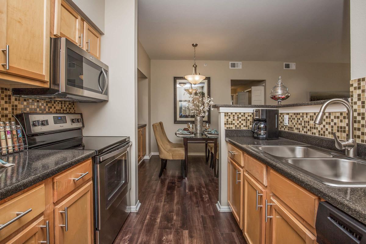 a modern kitchen with stainless steel appliances and wooden cabinets