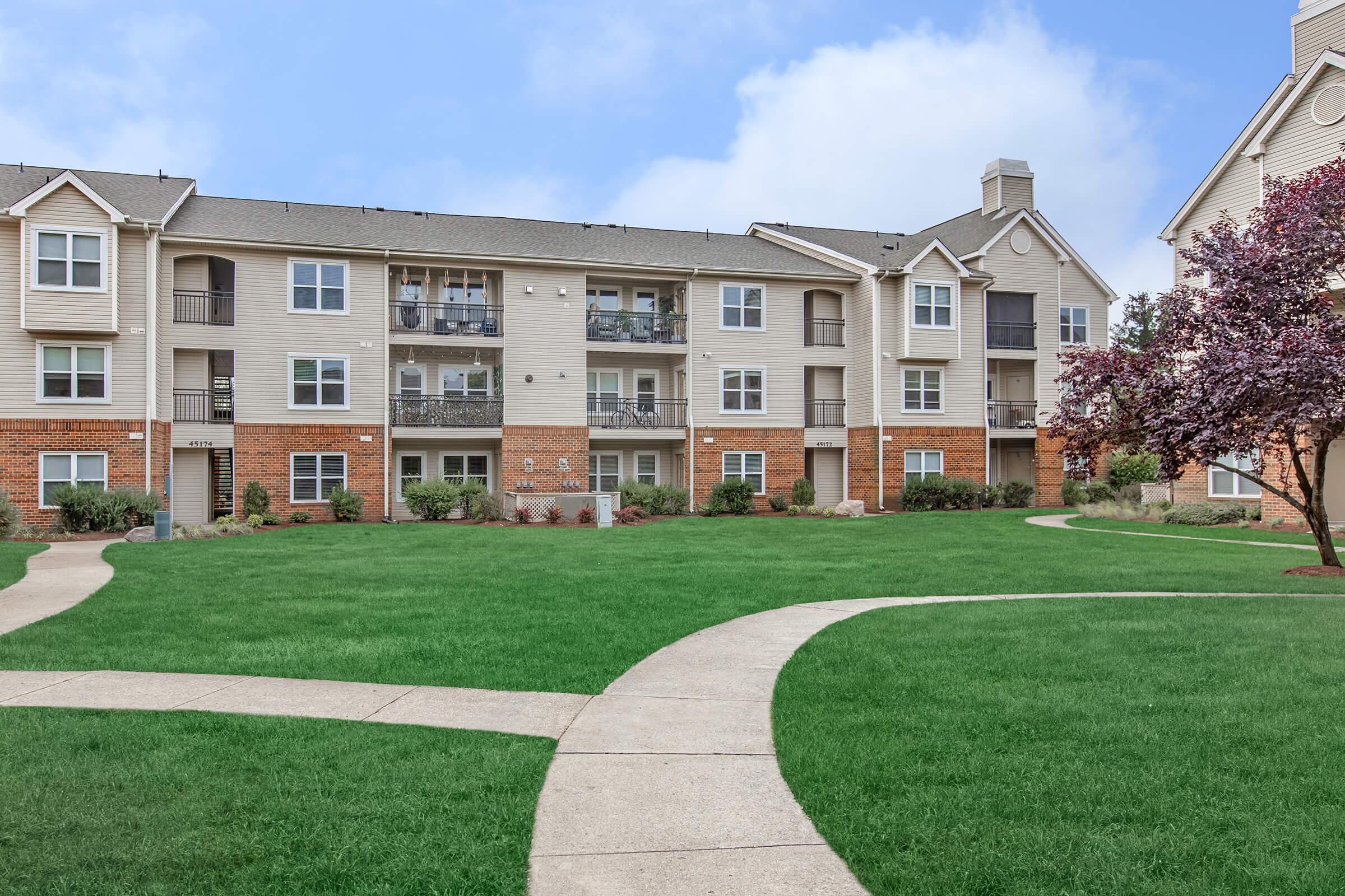 a large lawn in front of a brick building