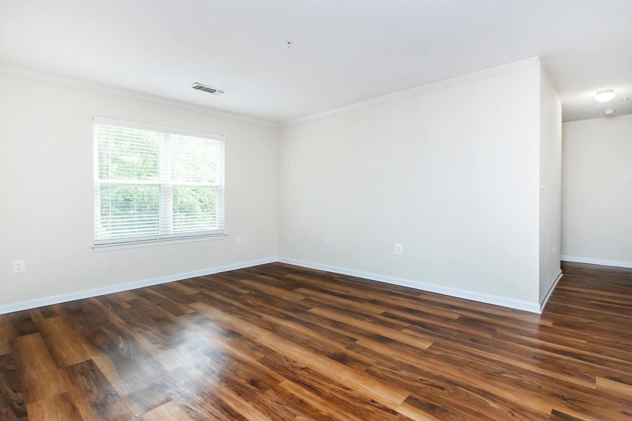 a close up of a hard wood floor next to a window