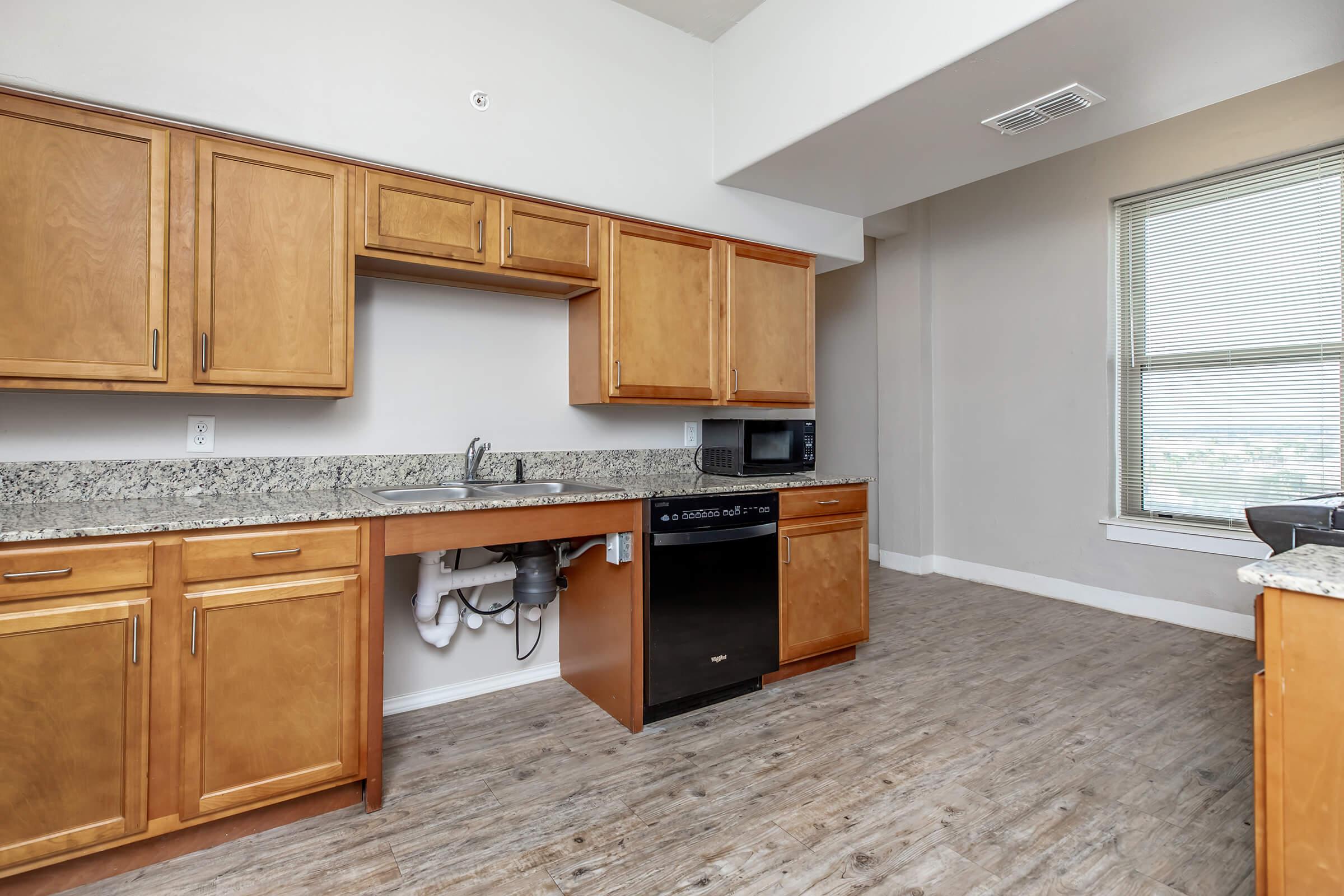 a large kitchen with stainless steel appliances and wooden cabinets