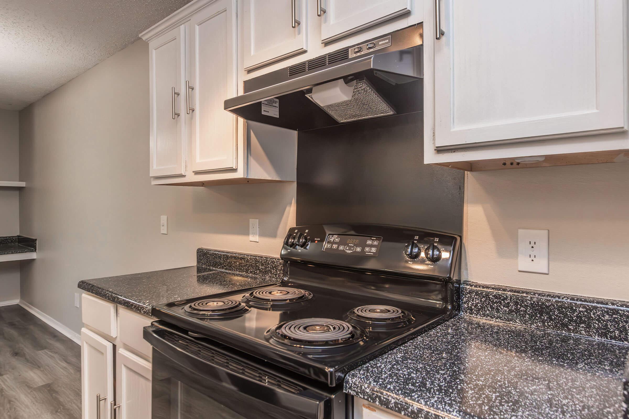 a stove top oven sitting inside of a kitchen