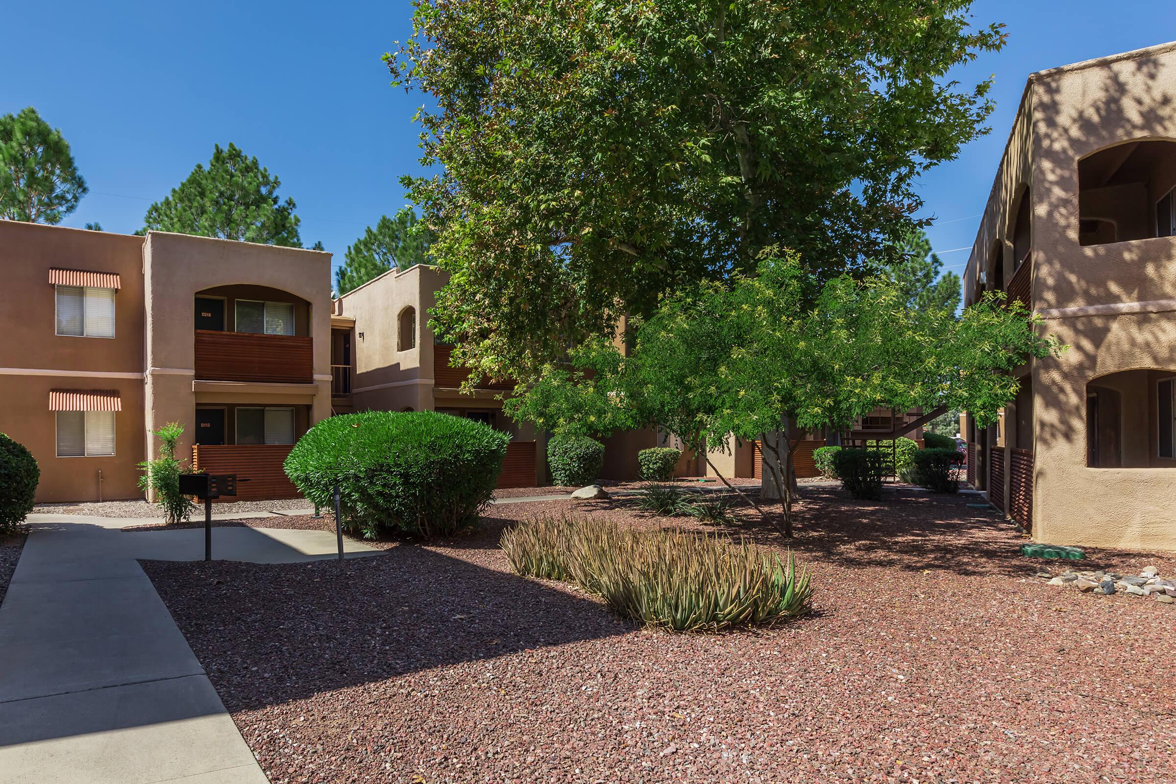 a house with bushes in front of a brick building