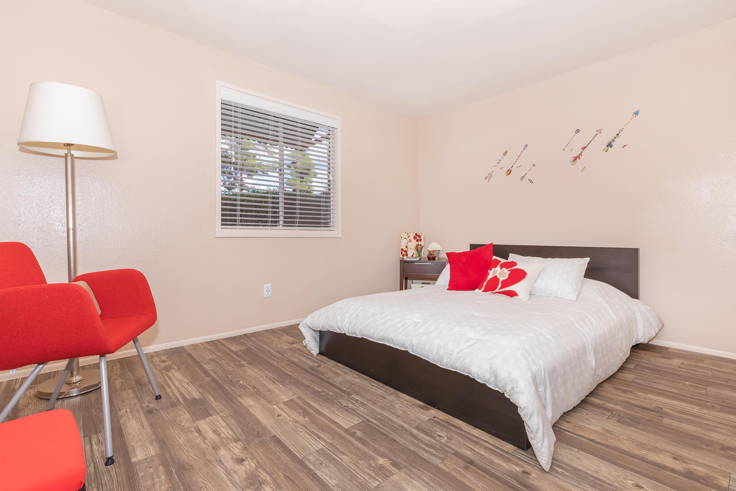 a bedroom with a large red chair in a room