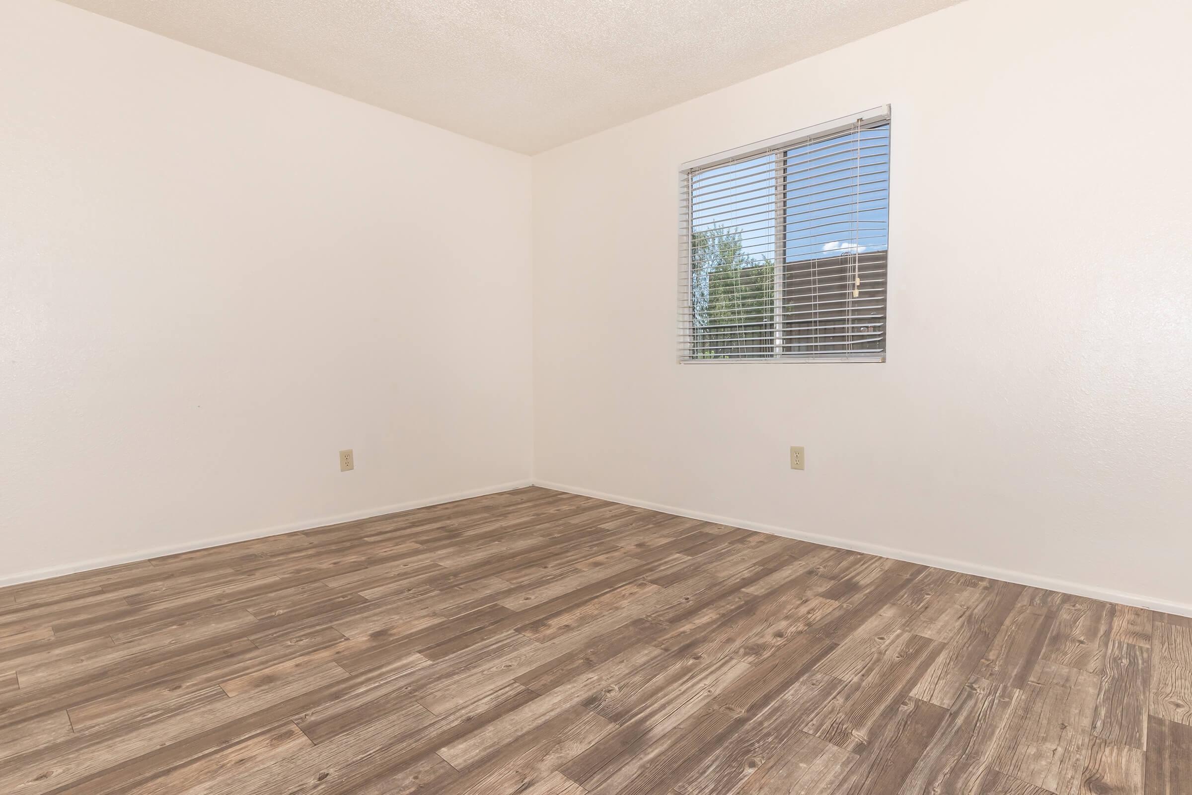 a bedroom with a wooden floor