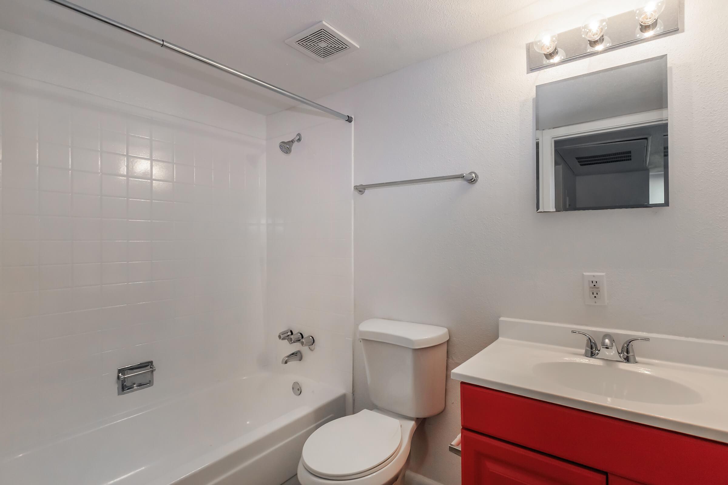 a white sink sitting under a mirror