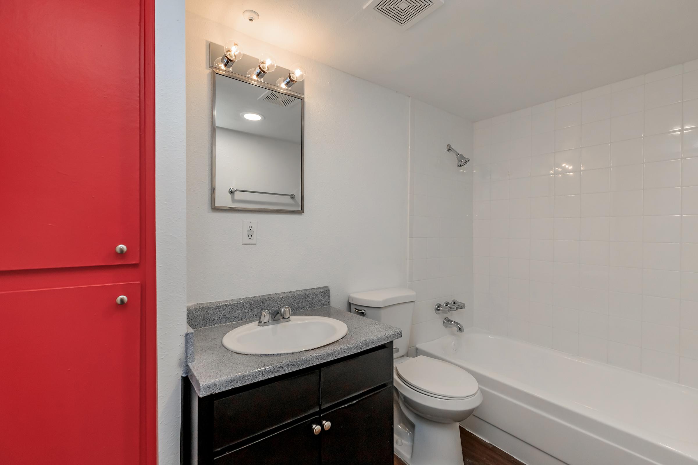 a white sink sitting under a mirror