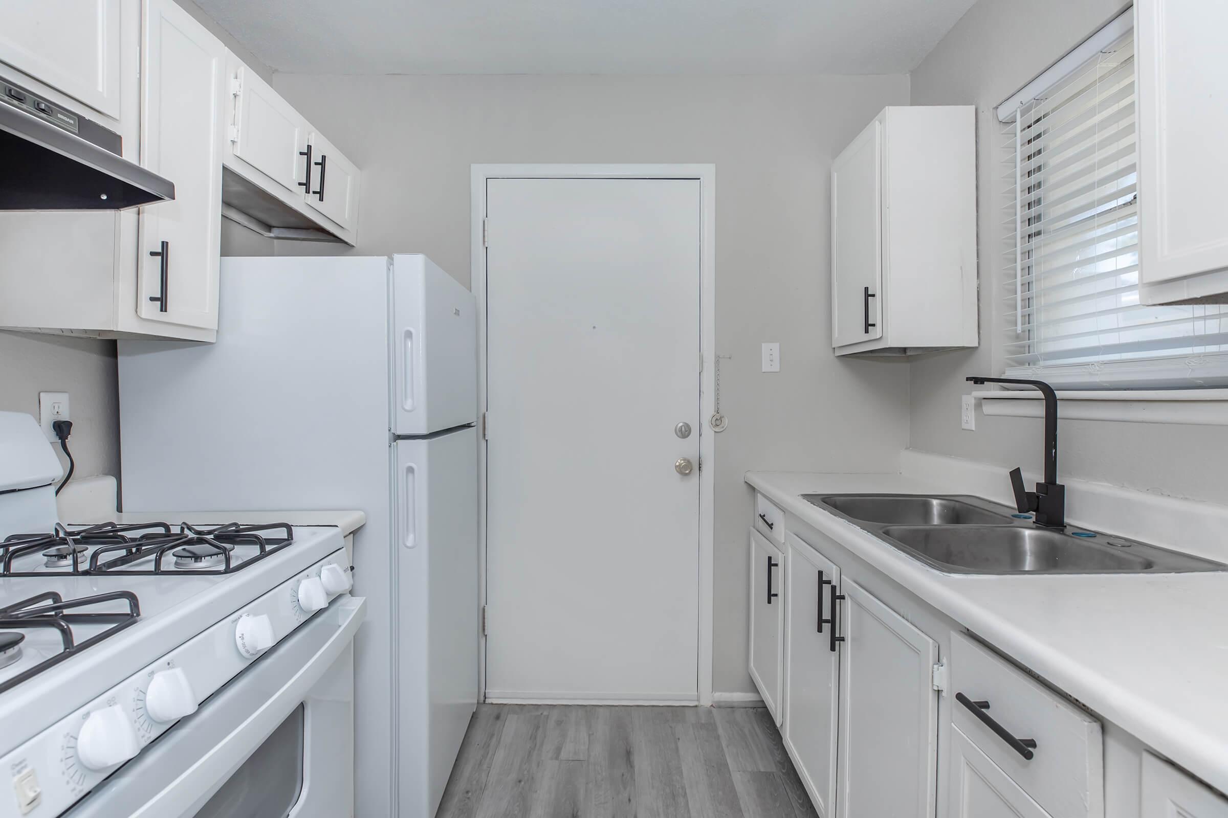 a kitchen with a stove sink and refrigerator