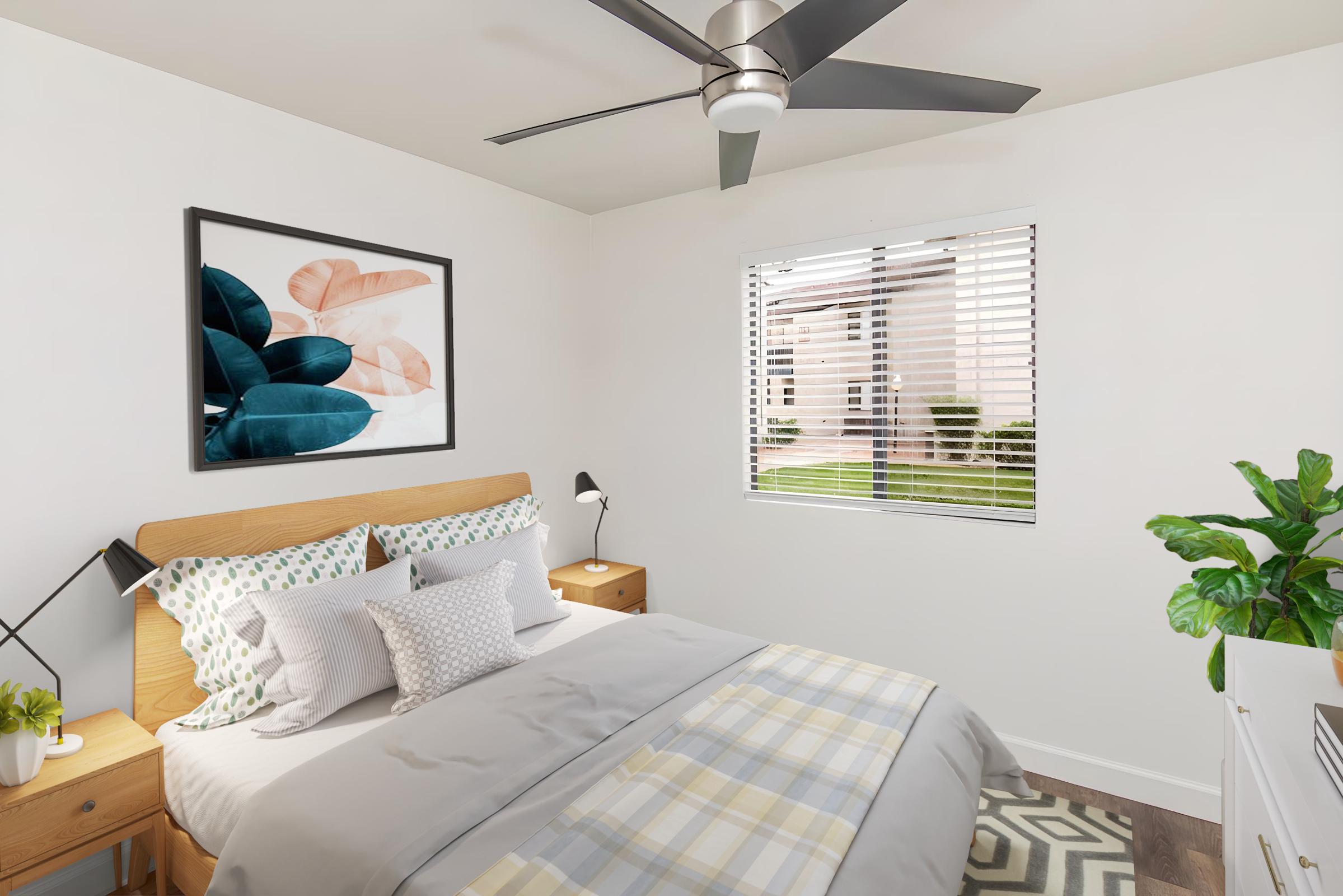 A cozy bedroom featuring a double bed with decorative pillows, a framed leaf artwork on the wall, bedside tables with lamps, a window with blinds letting in natural light, and a small indoor plant by the dresser. The room has a light color scheme and stylish decor, creating a welcoming atmosphere.