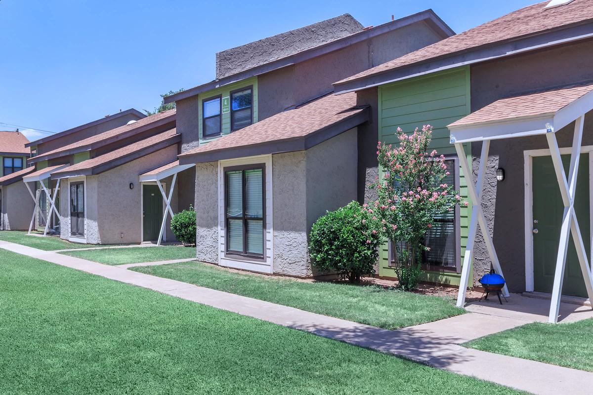 a house with a lawn in front of a brick building